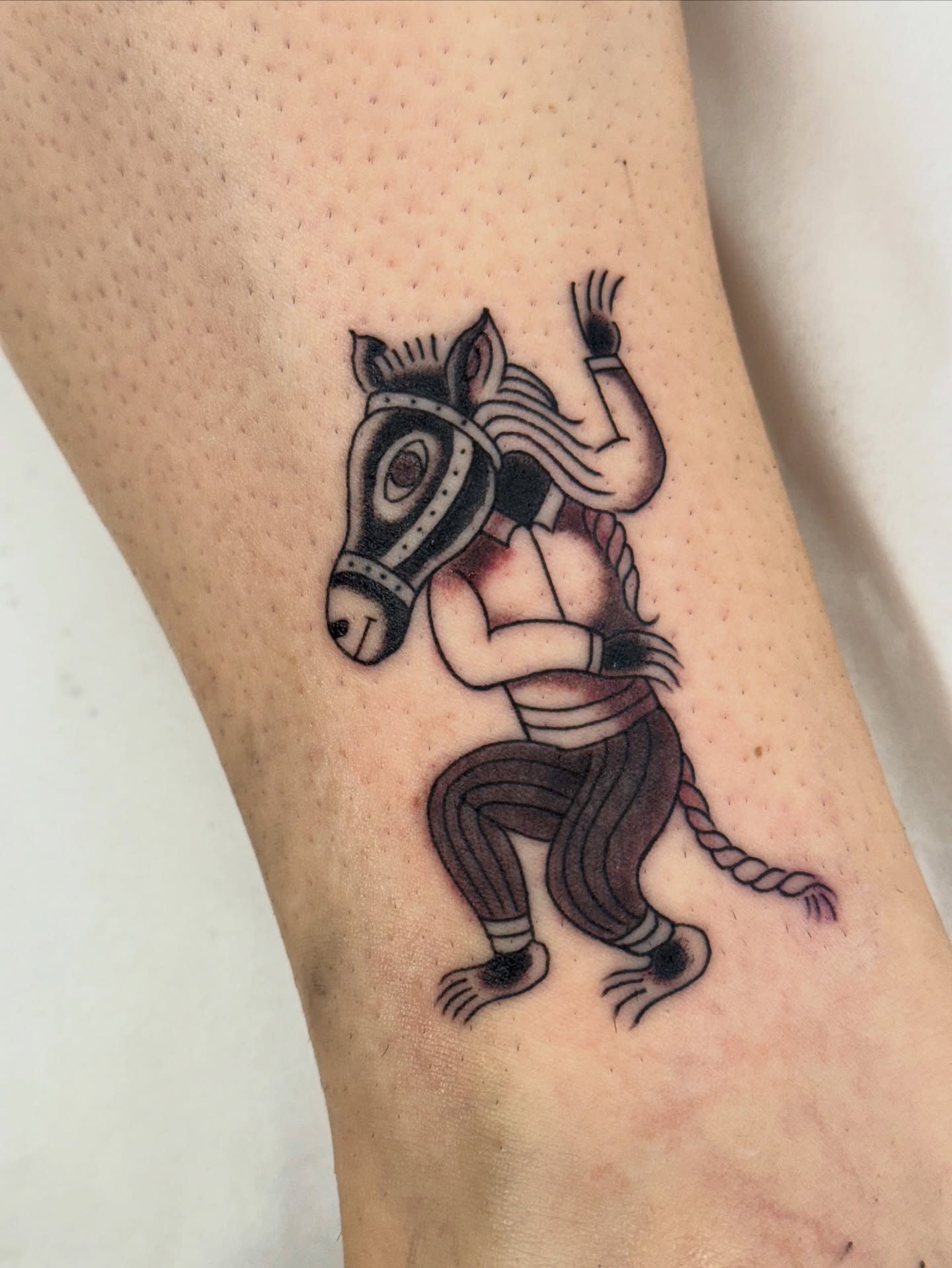 Horse-headed humanoid neo-traditional tattoo on the forearm by Chris Orta