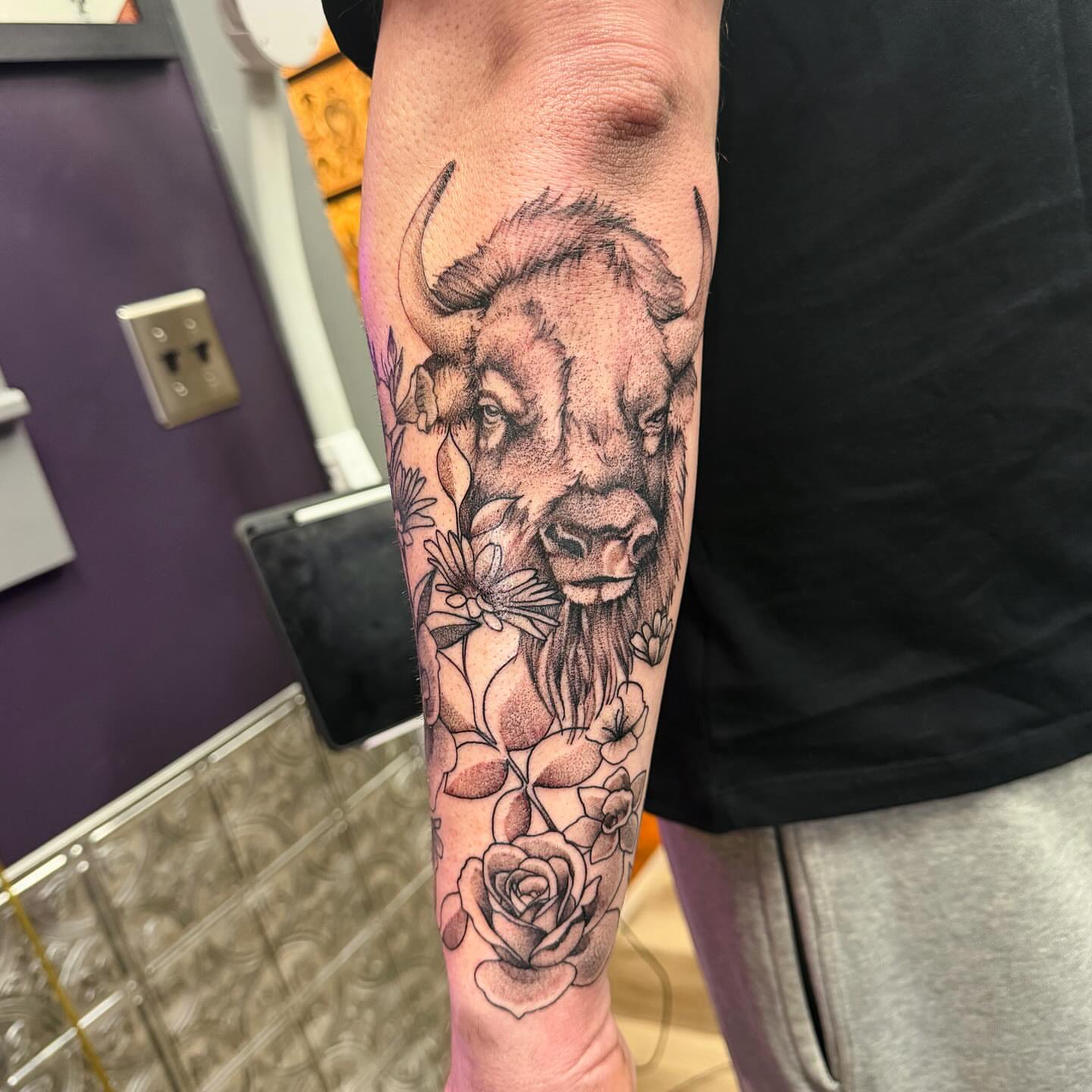 Buffalo and flowers realism tattoo on the forearm by Emily