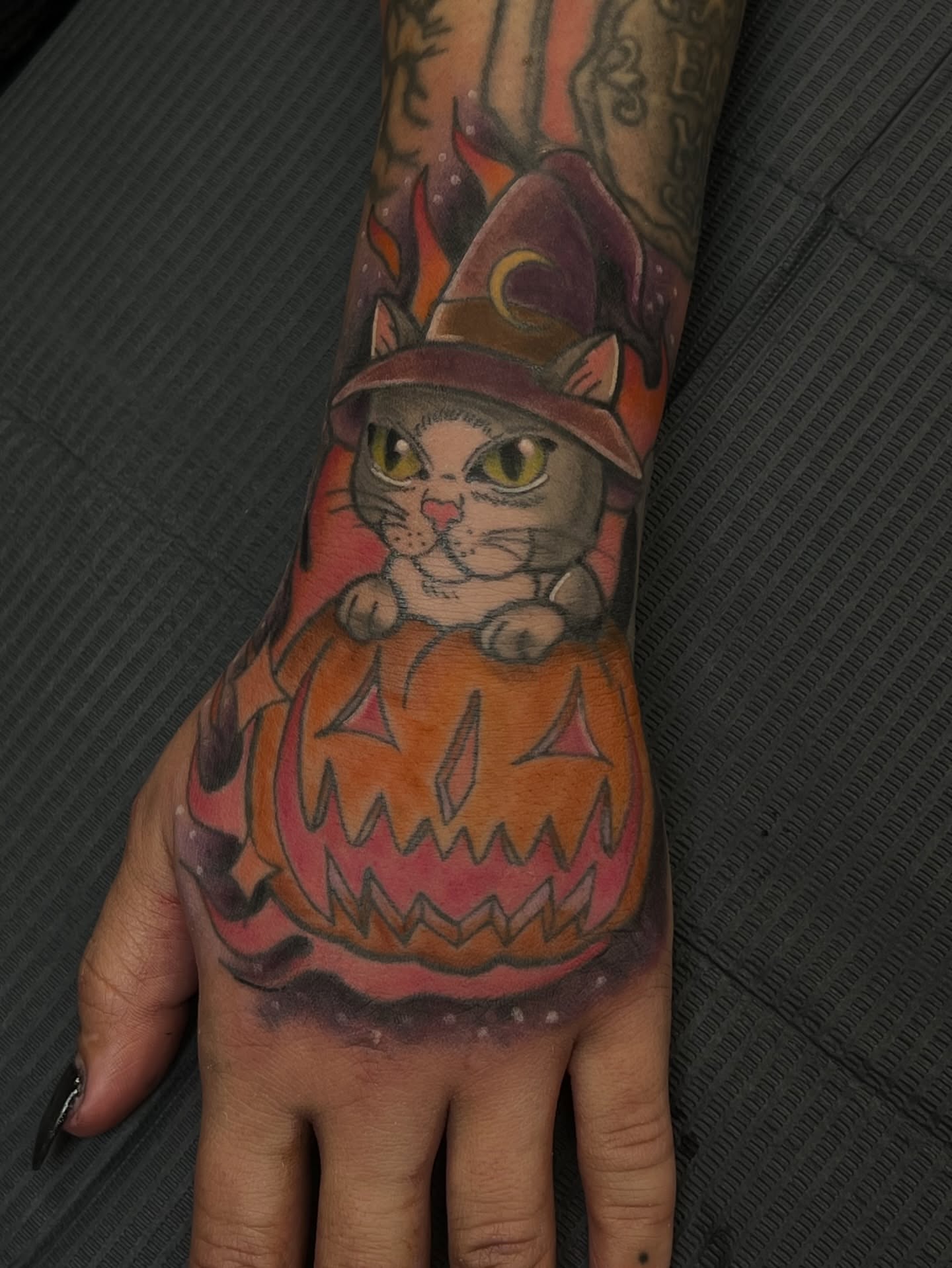 Cat in pumpkin realism tattoo on the hand by Leslie Paskoff