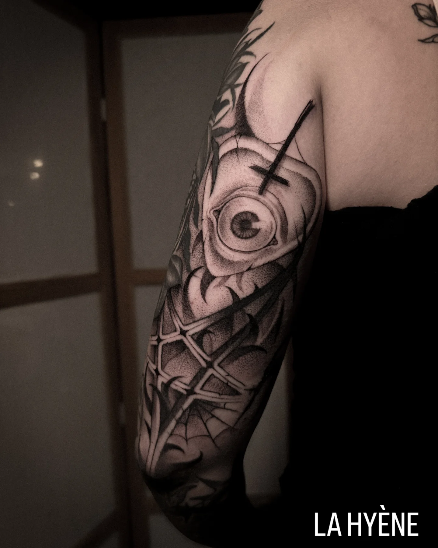 Eye and cross geometric tattoo on the forearm by La Hyene