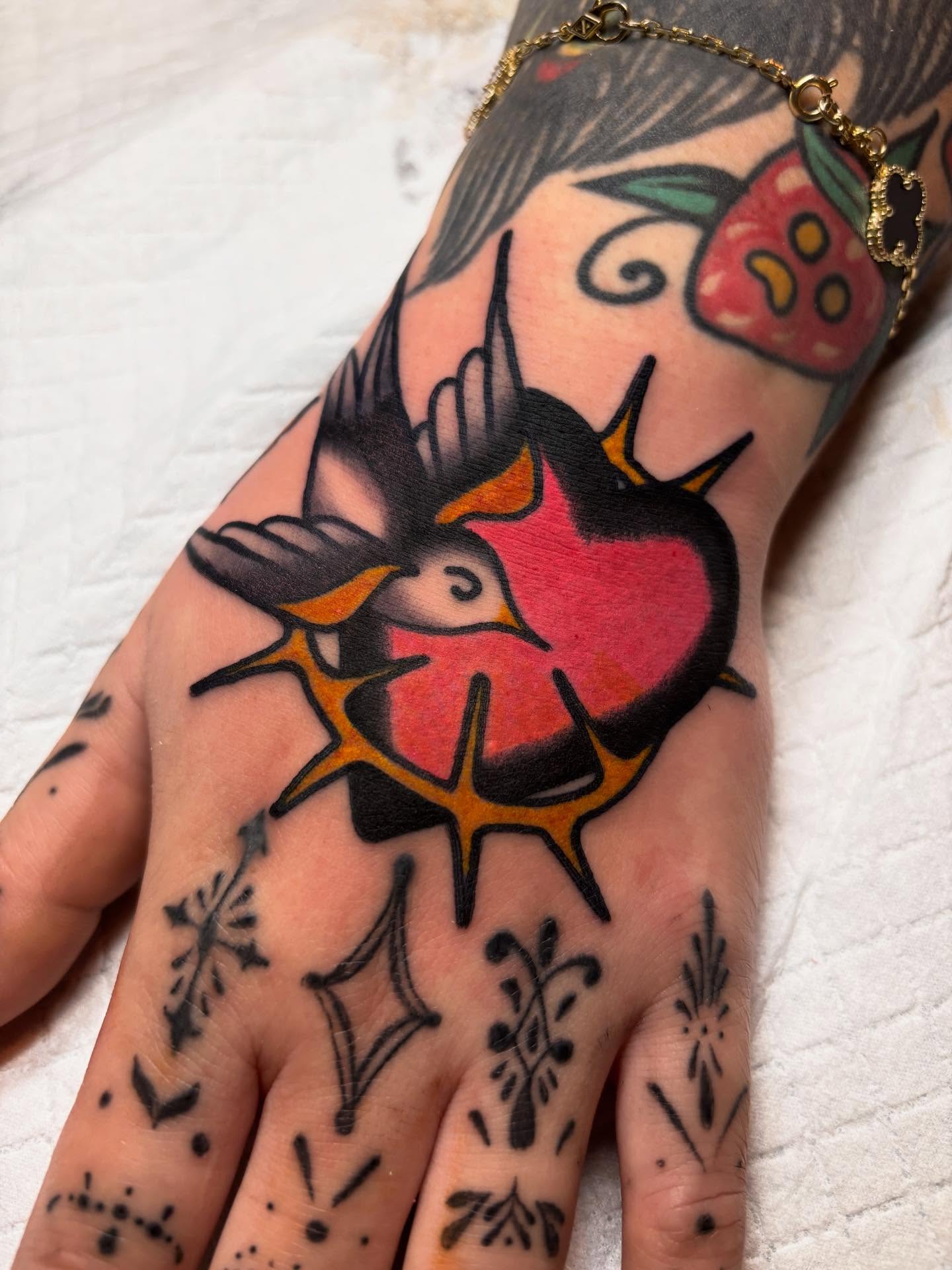 Swallow and heart American traditional tattoo on the hand by ๐๐ซ๐ข๐ ๐๐ฅ๐ญ๐จ๐ง๐๐ง