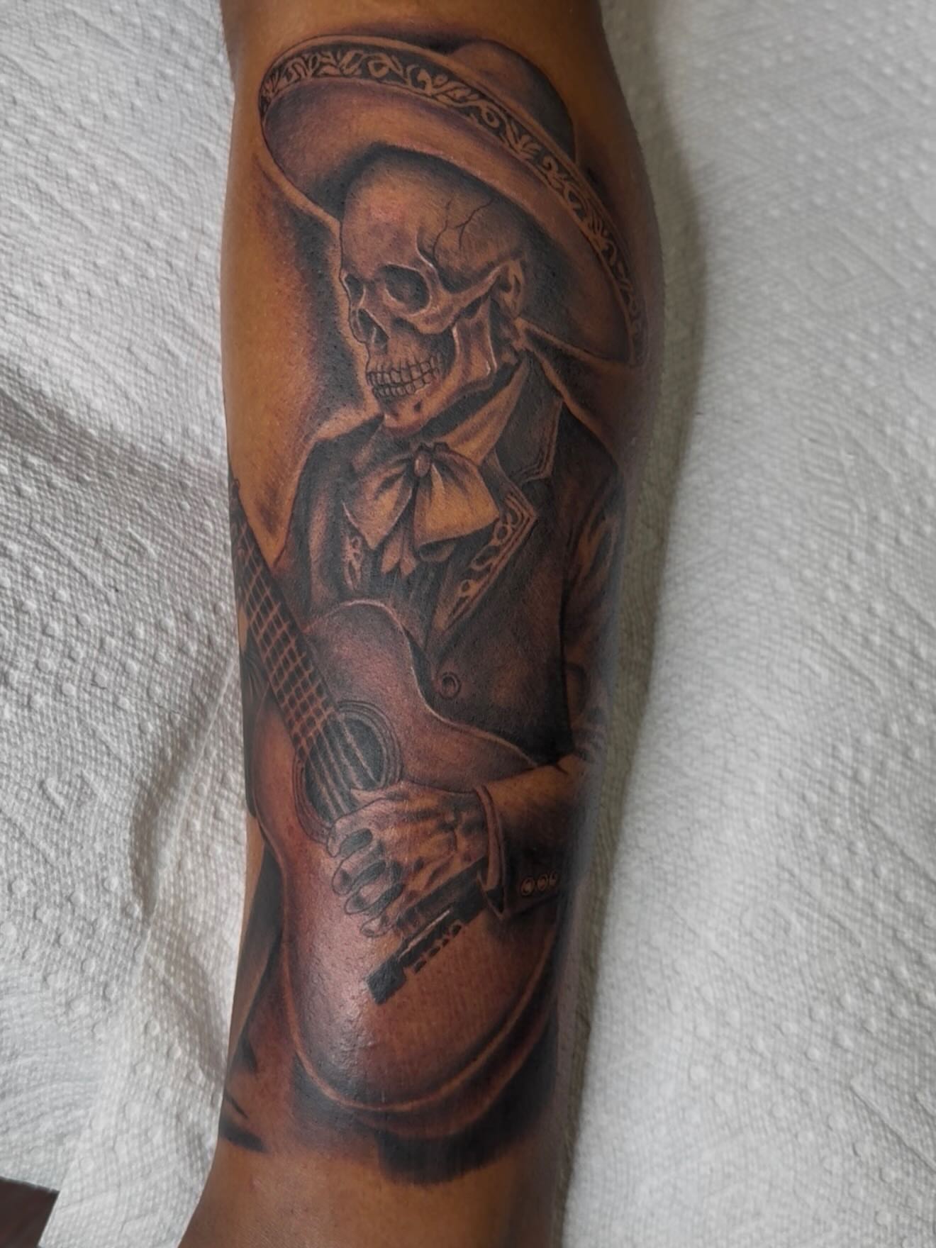 Skull playing guitar realism tattoo on the forearm by Las Vegas Tattoo Artist