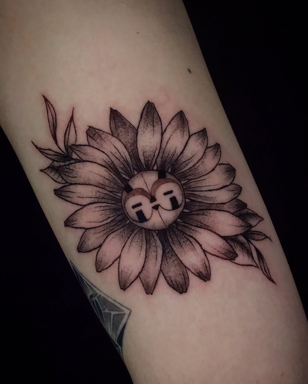 Flower with character face dotwork tattoo on the forearm by Kanya, Alhambra, California