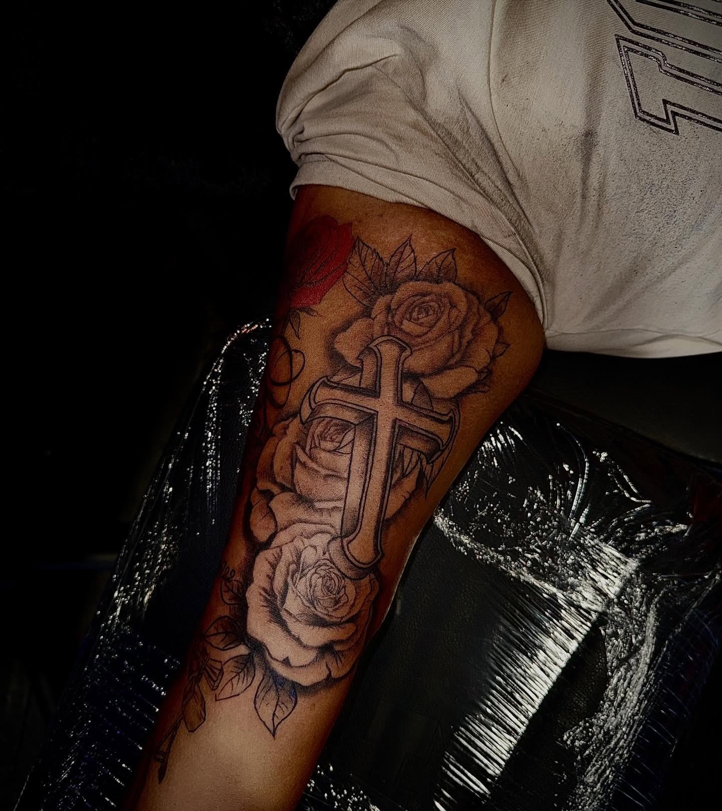 Cross and roses black and grey tattoo on the forearm by Clifford Jordan