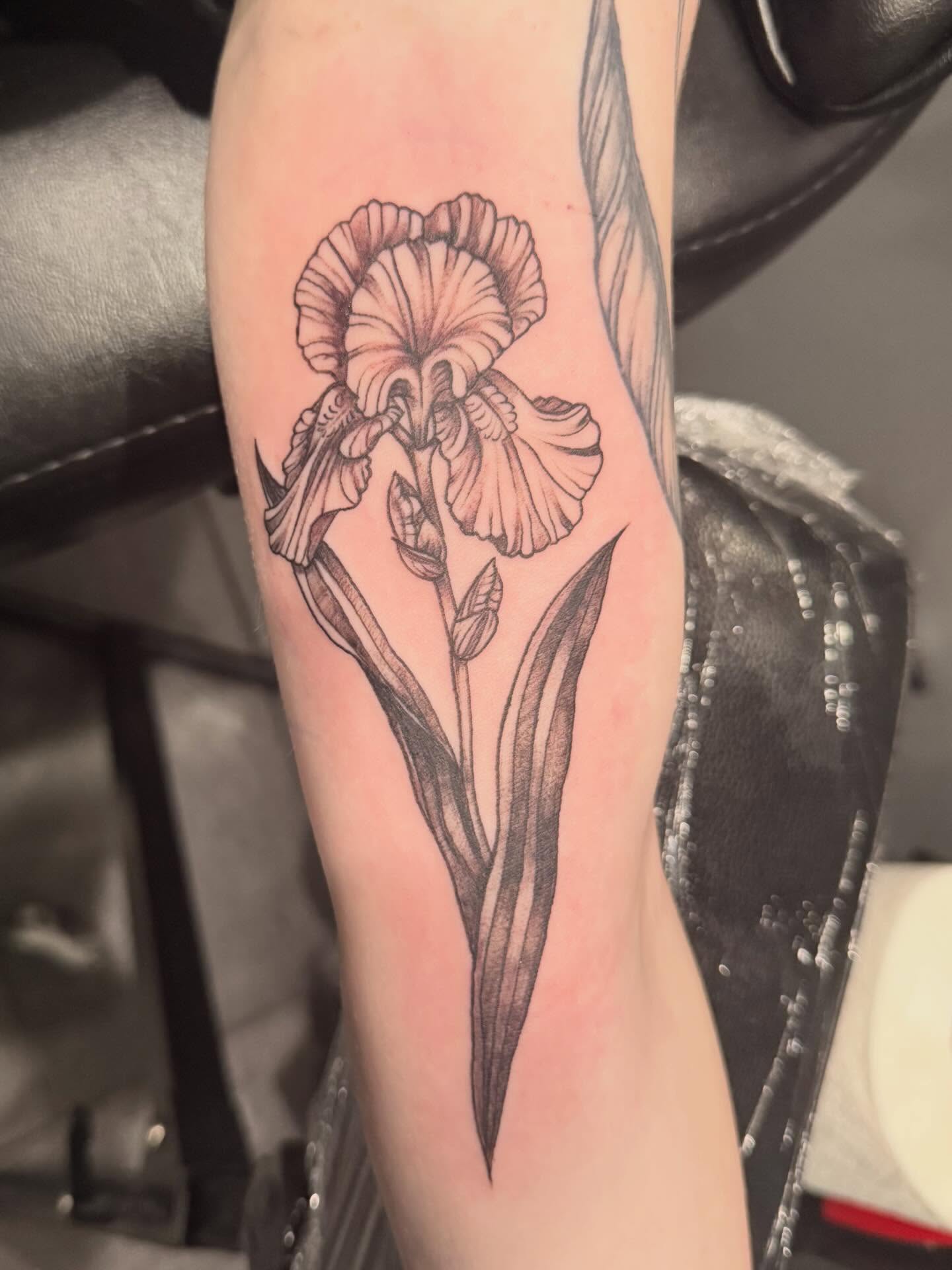 Iris flower black and grey tattoo on the forearm by Courtney