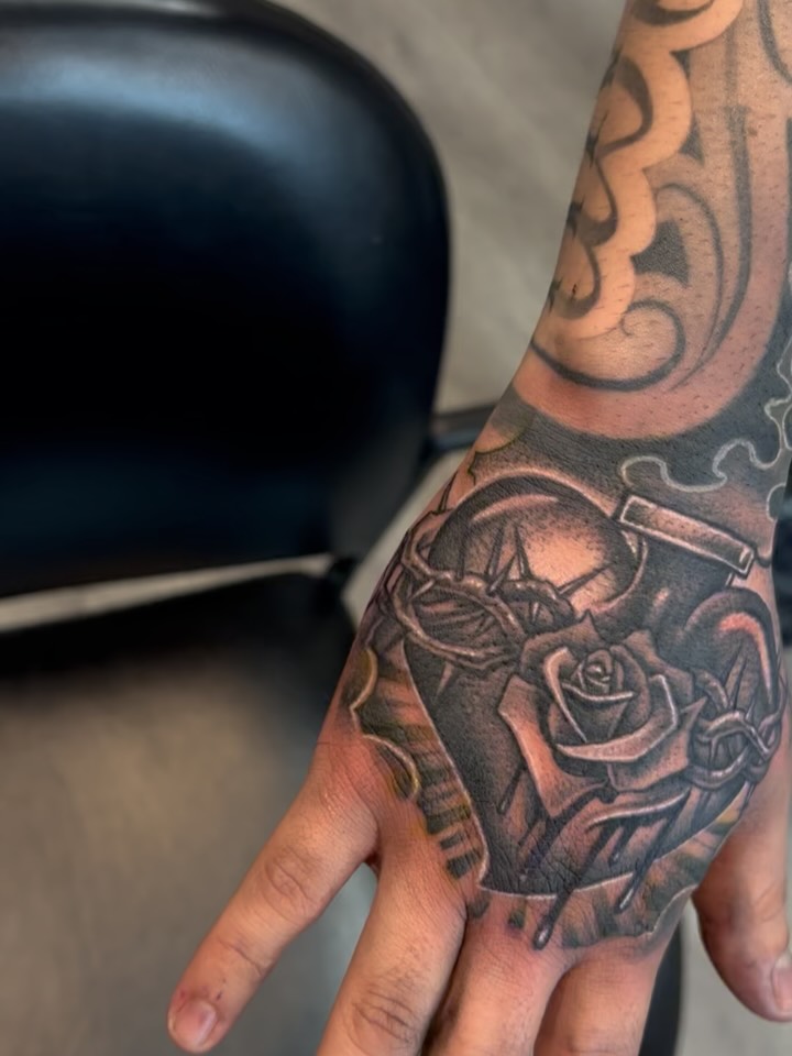 Mechanical heart with rose realism tattoo on the hand by michael