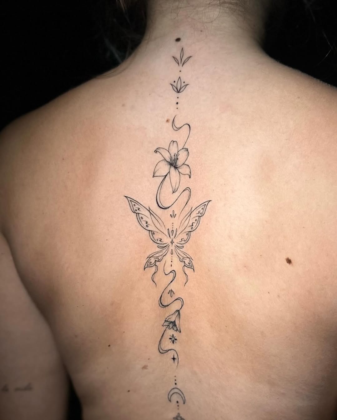 Butterfly and floral elements ornamental tattoo on the back by Frida Tattooista