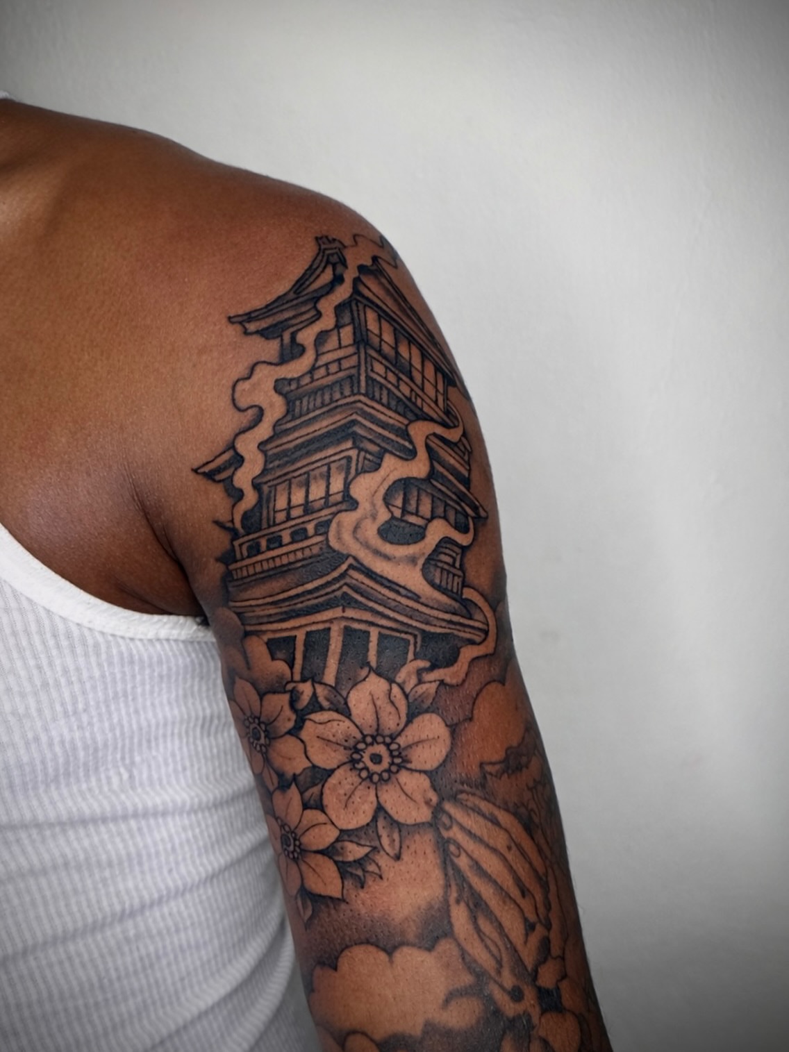 Chinese pagoda and flowers black and grey tattoo on the upper arm by JayyeSosa