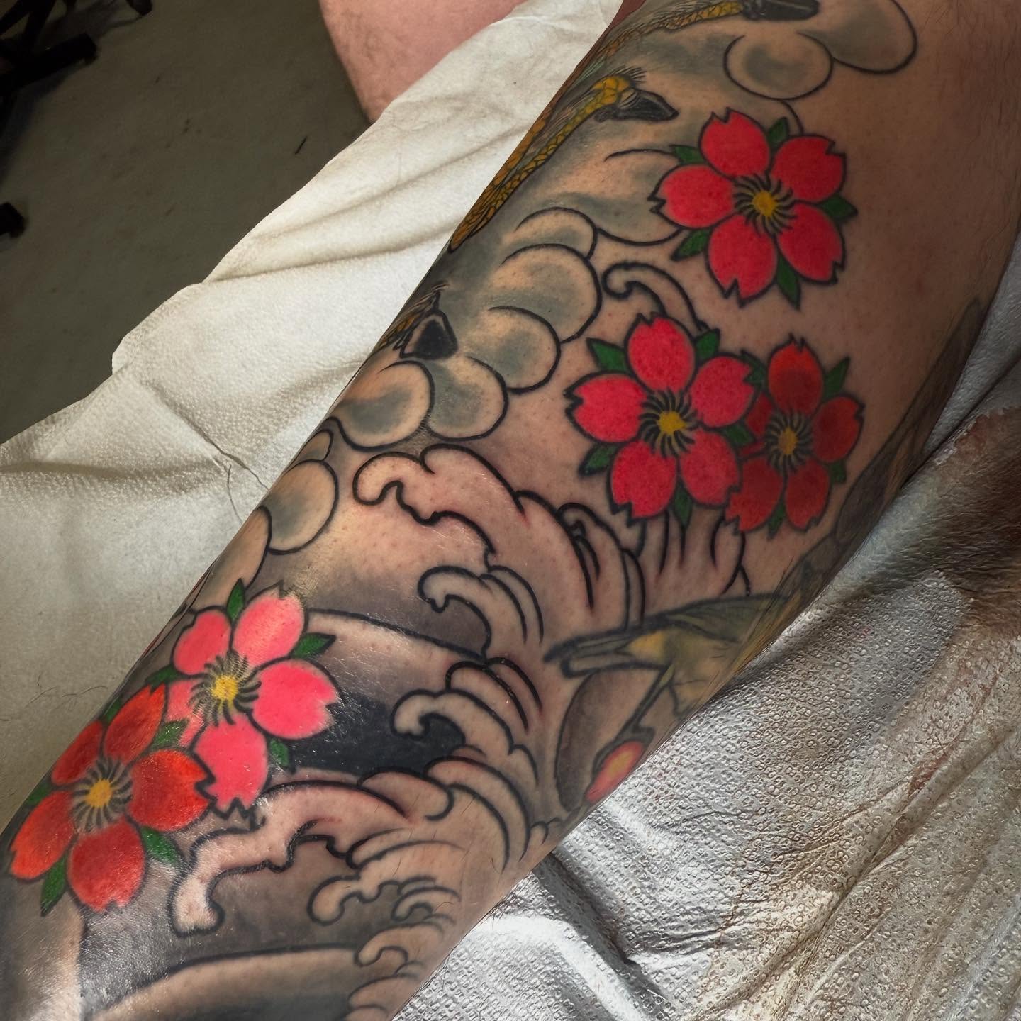 Cherry blossoms and waves American traditional tattoo on the forearm by Randall Croley El