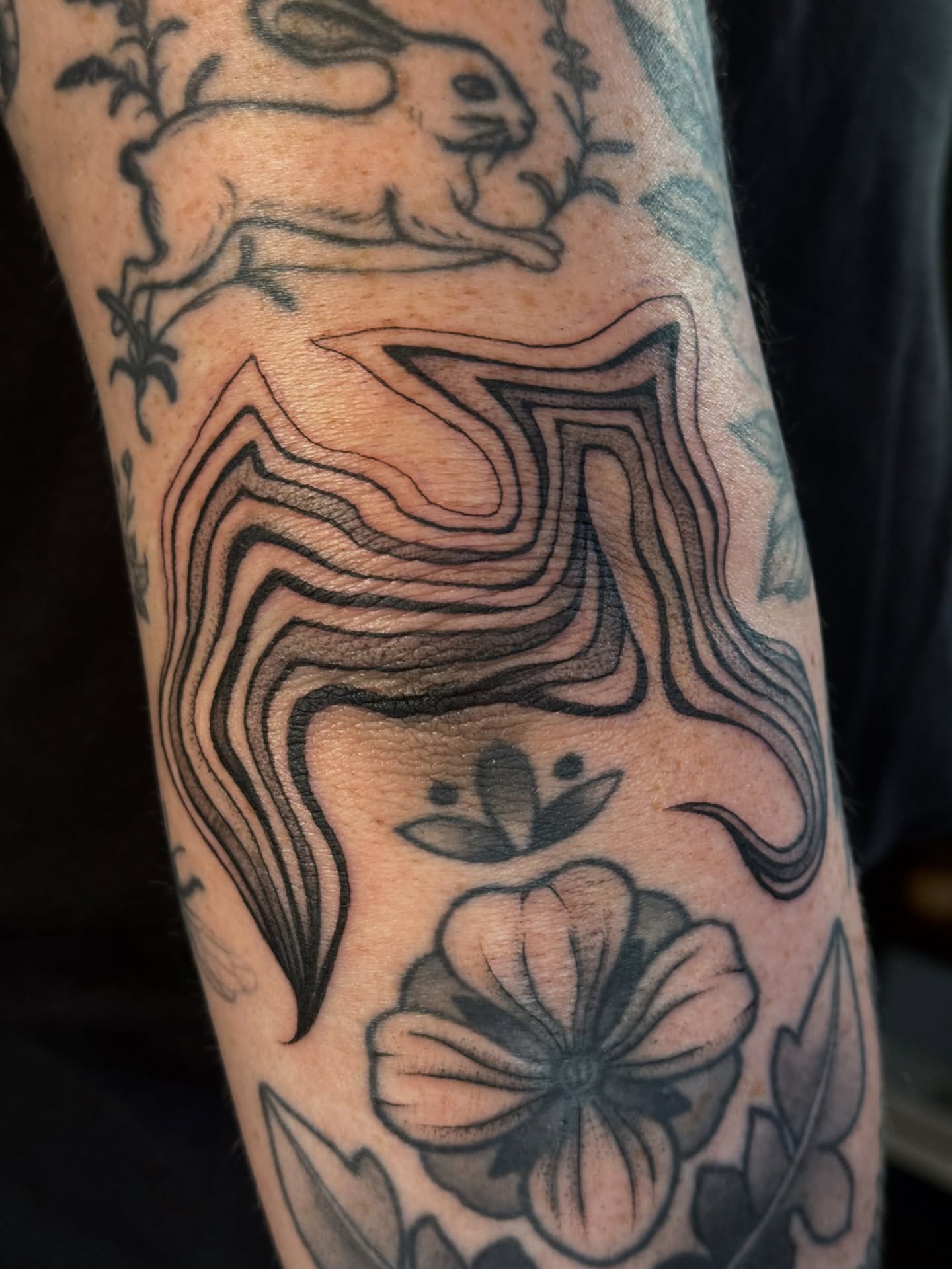 Abstract wave pattern black and grey tattoo on the forearm by Paul DeVay