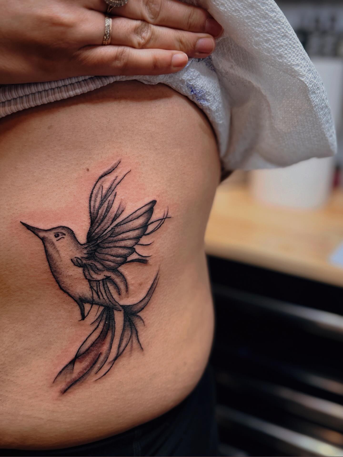 Bird black and grey tattoo on the ribs by Alesia