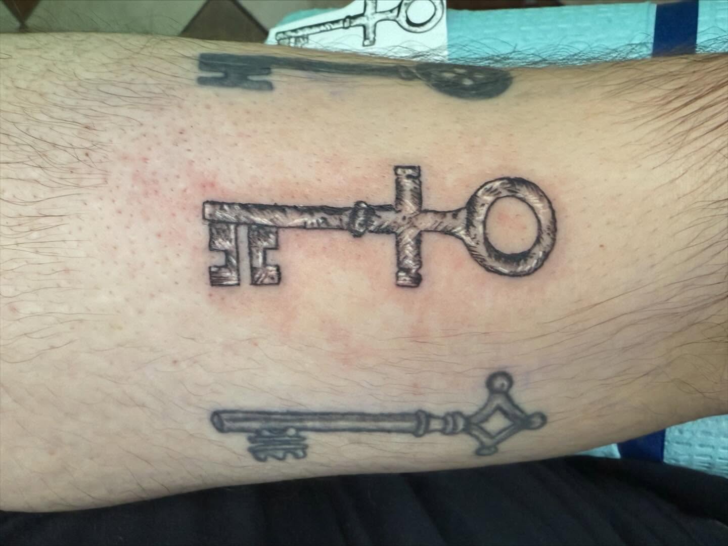Key black and grey tattoo on the forearm by Nina Rush