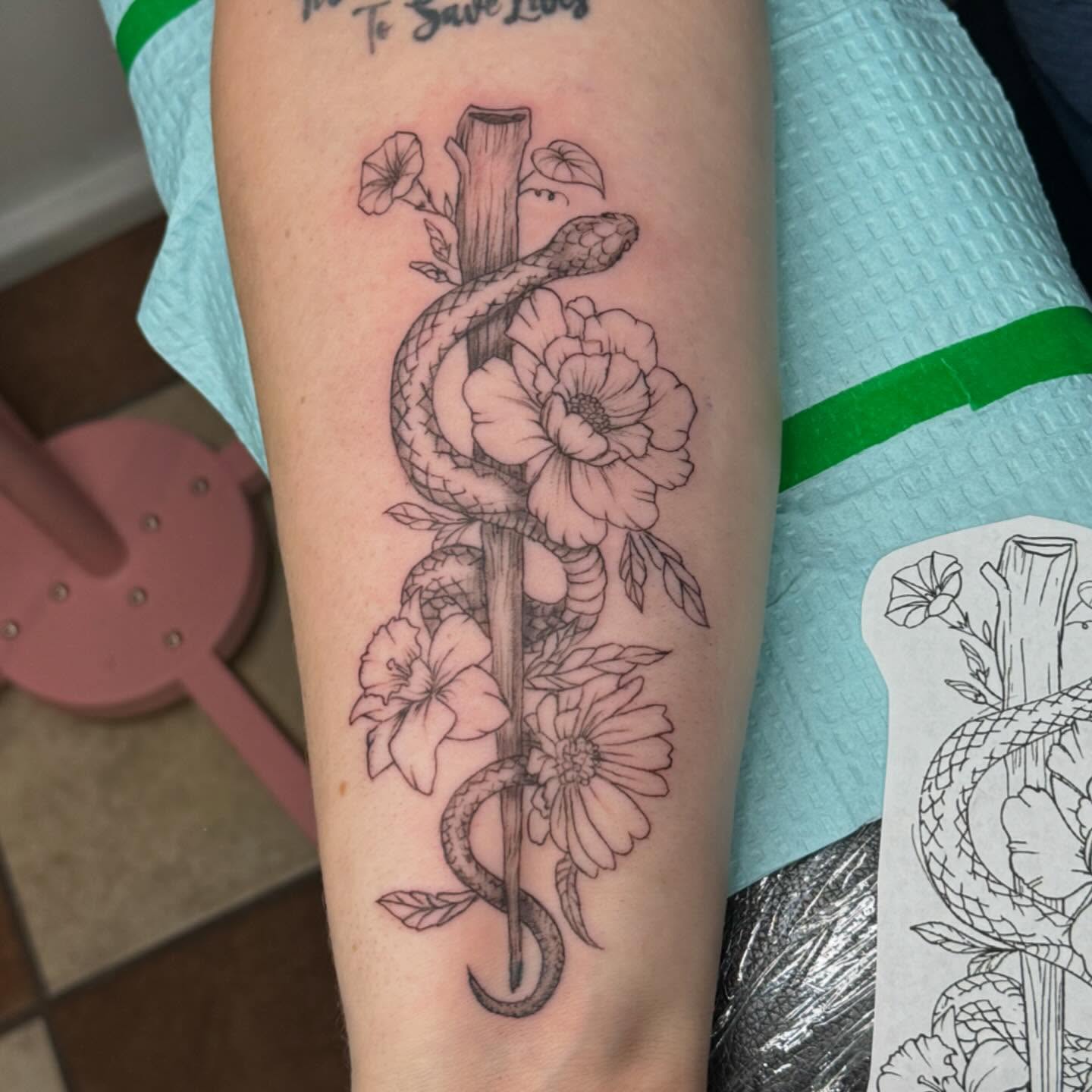 Snake and flowers realism tattoo on the forearm by Nina Rush