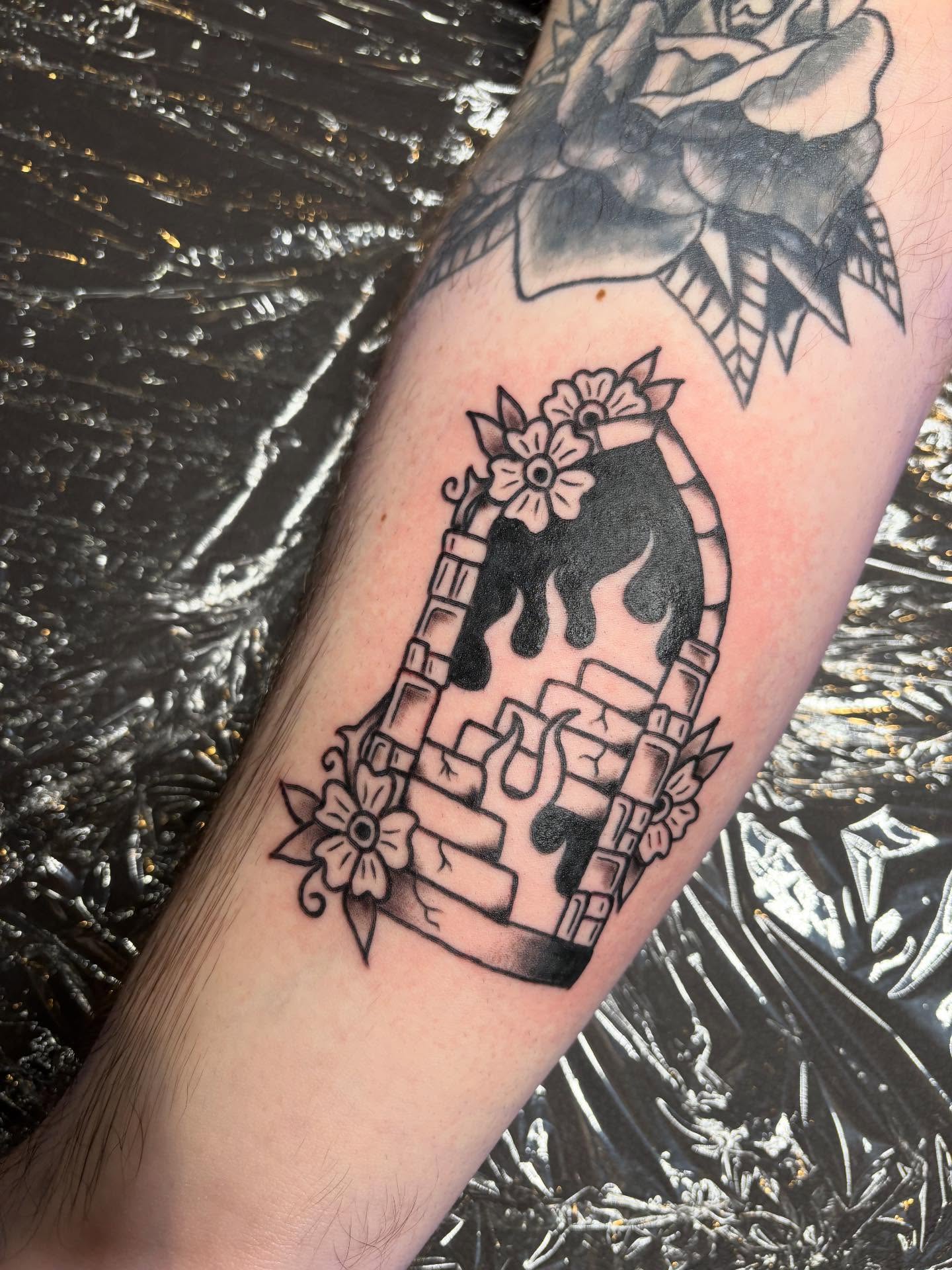 Skull in bookshelf black and grey tattoo on the forearm by ellie