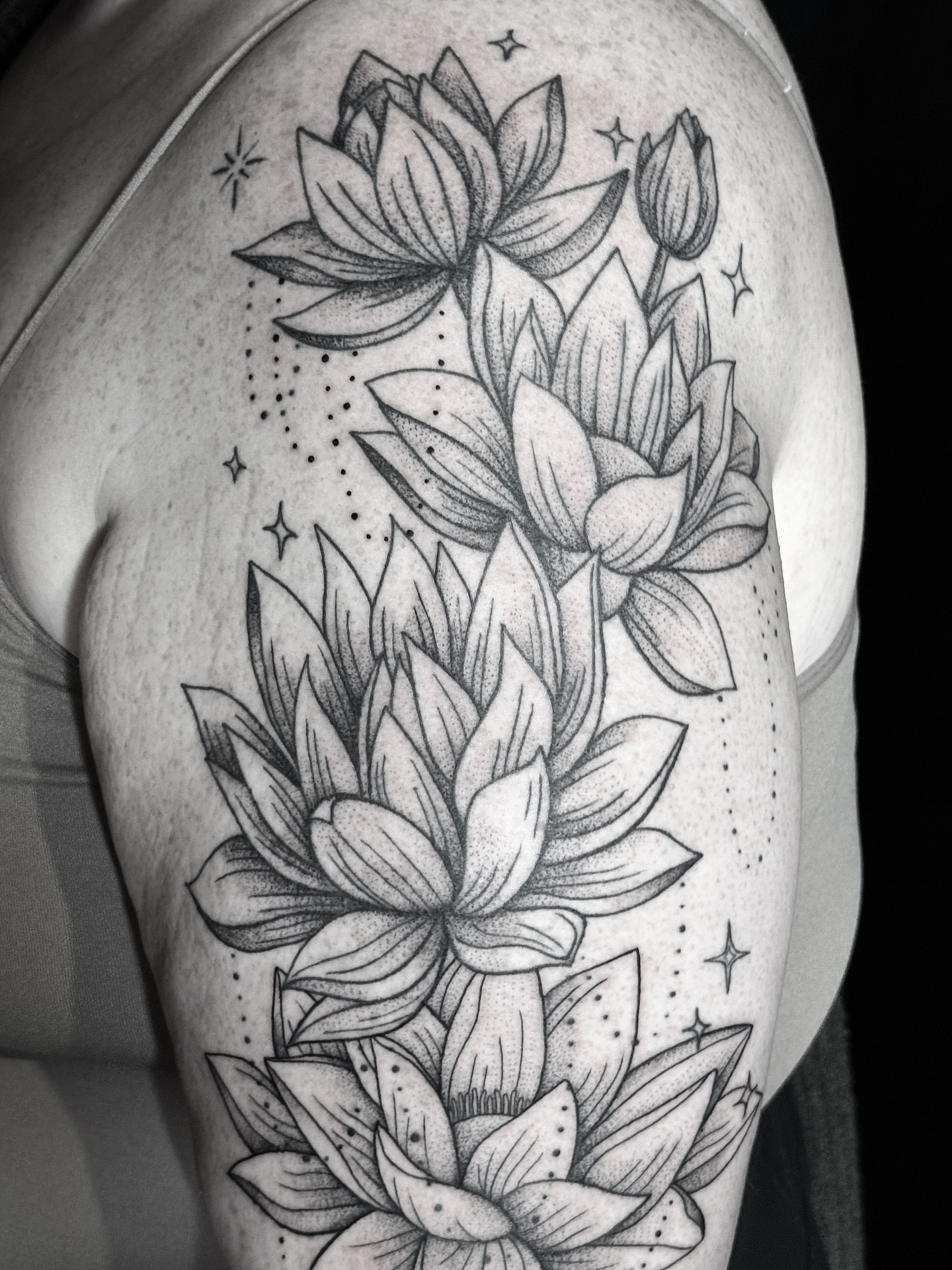 Lotus flowers dotwork tattoo on the shoulder by Breezy Tucker