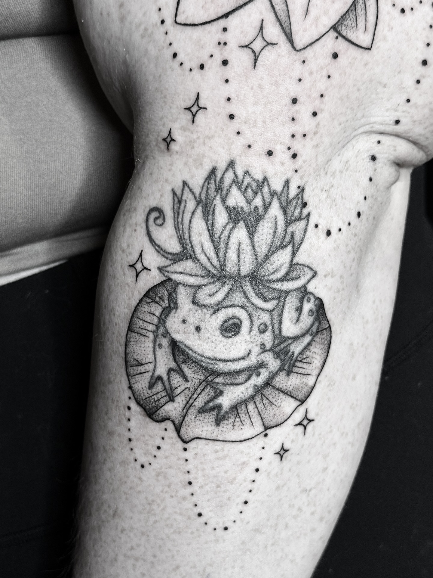 Lotus flower dotwork tattoo on the thigh by Breezy Tucker