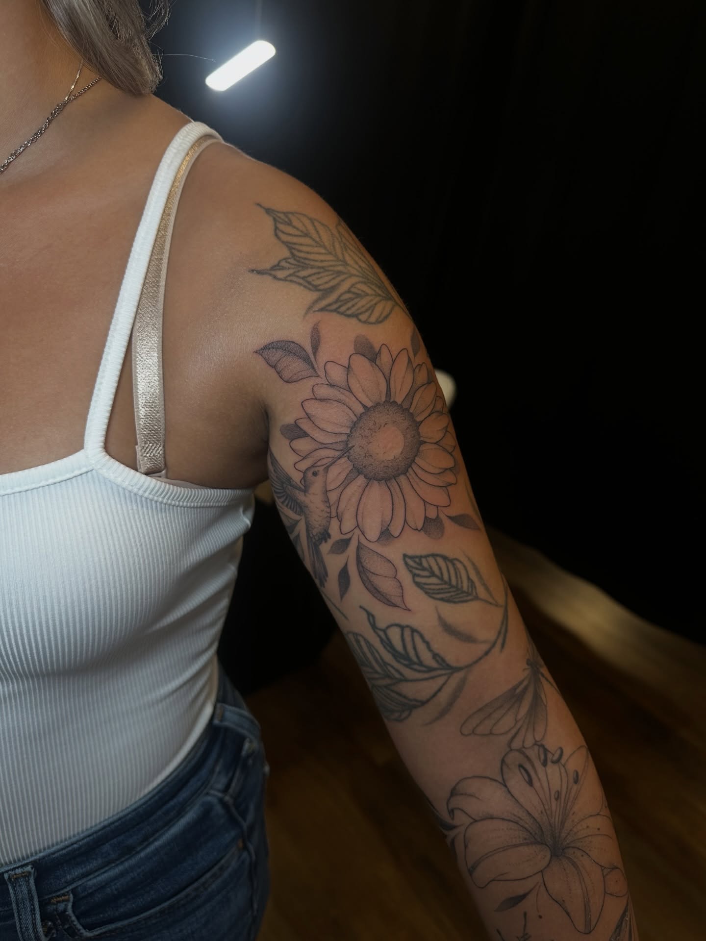 Sunflower black and grey tattoo on the upper arm by Priscilla Michels