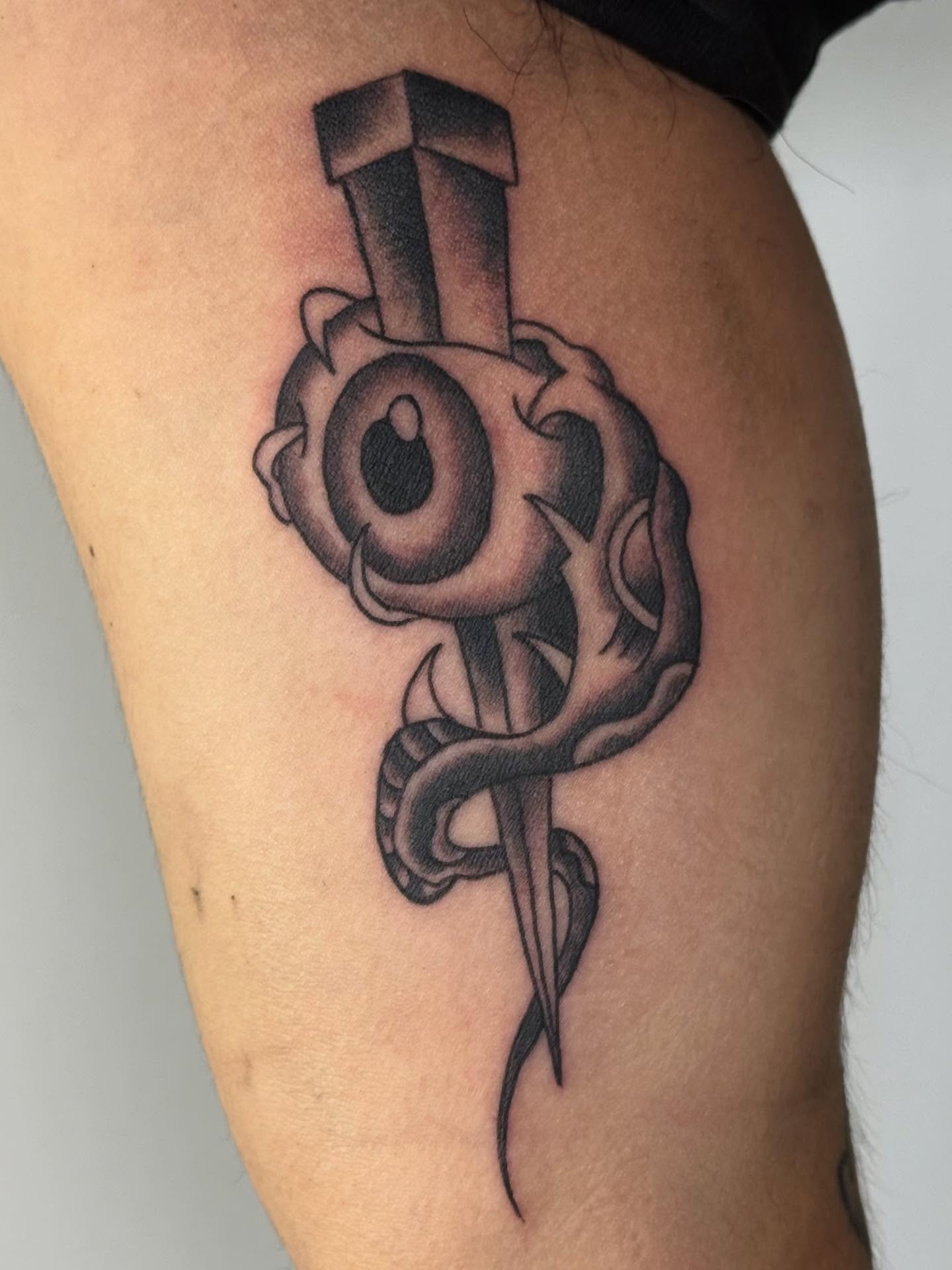 Eye and dagger black and grey tattoo on the thigh by Rigo Vargas