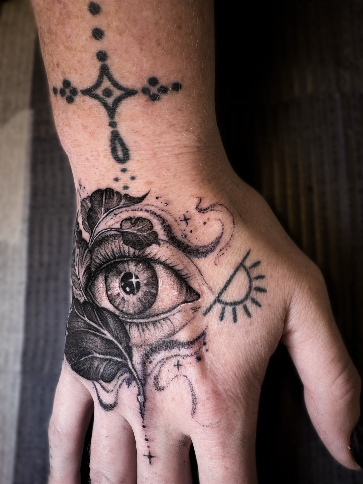 Eye and leaf realism tattoo on the hand by Jen Petronella