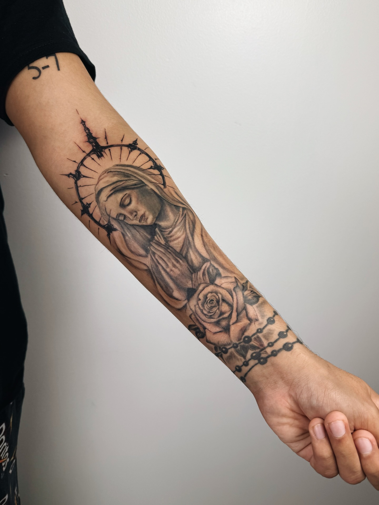 Religious figure with roses realism tattoo on the forearm by viktoria raquel