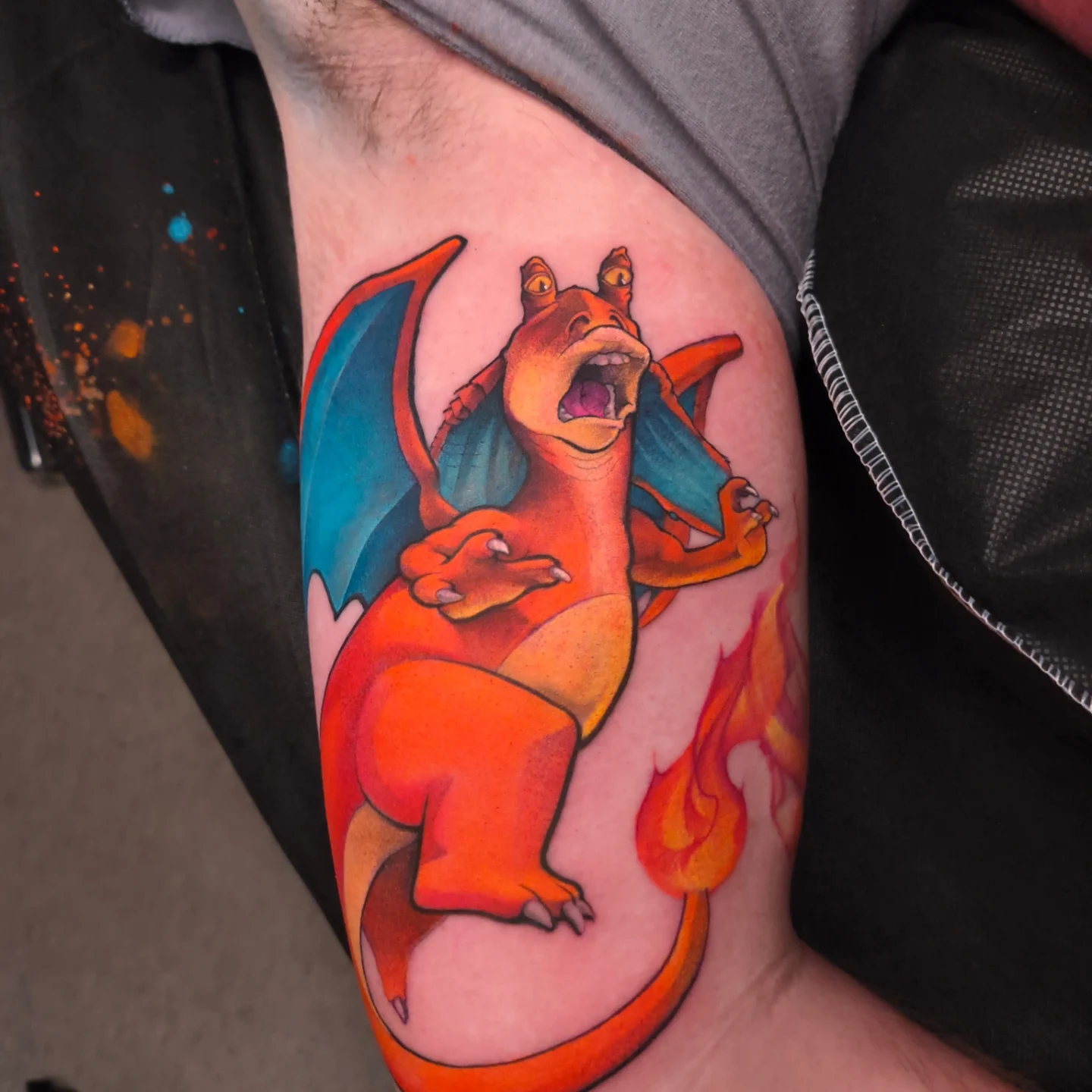 Charizard new school tattoo on the thigh by Jorell Elie