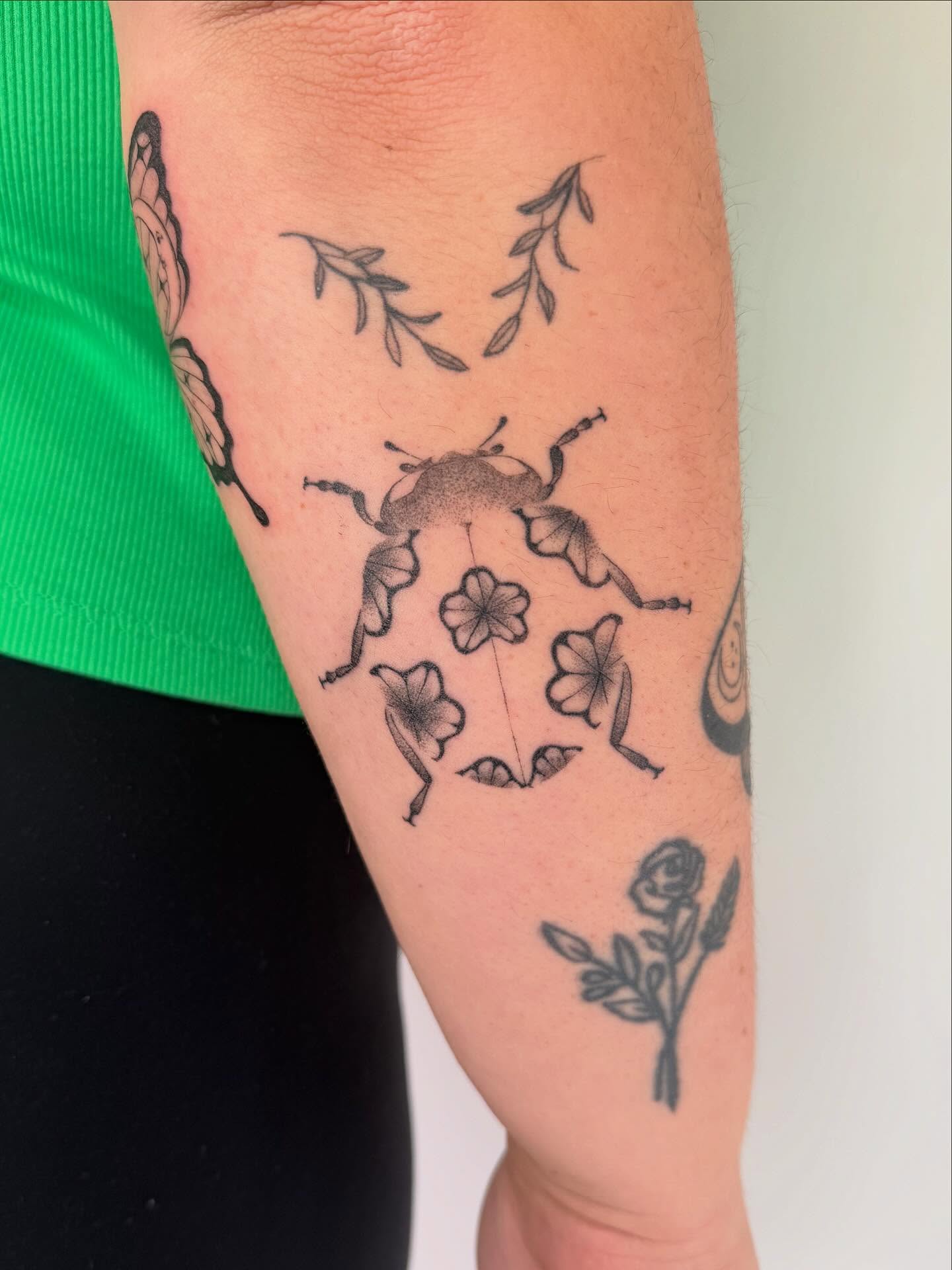 Beetle and flowers black and grey tattoo on the forearm by Leah Ramos
