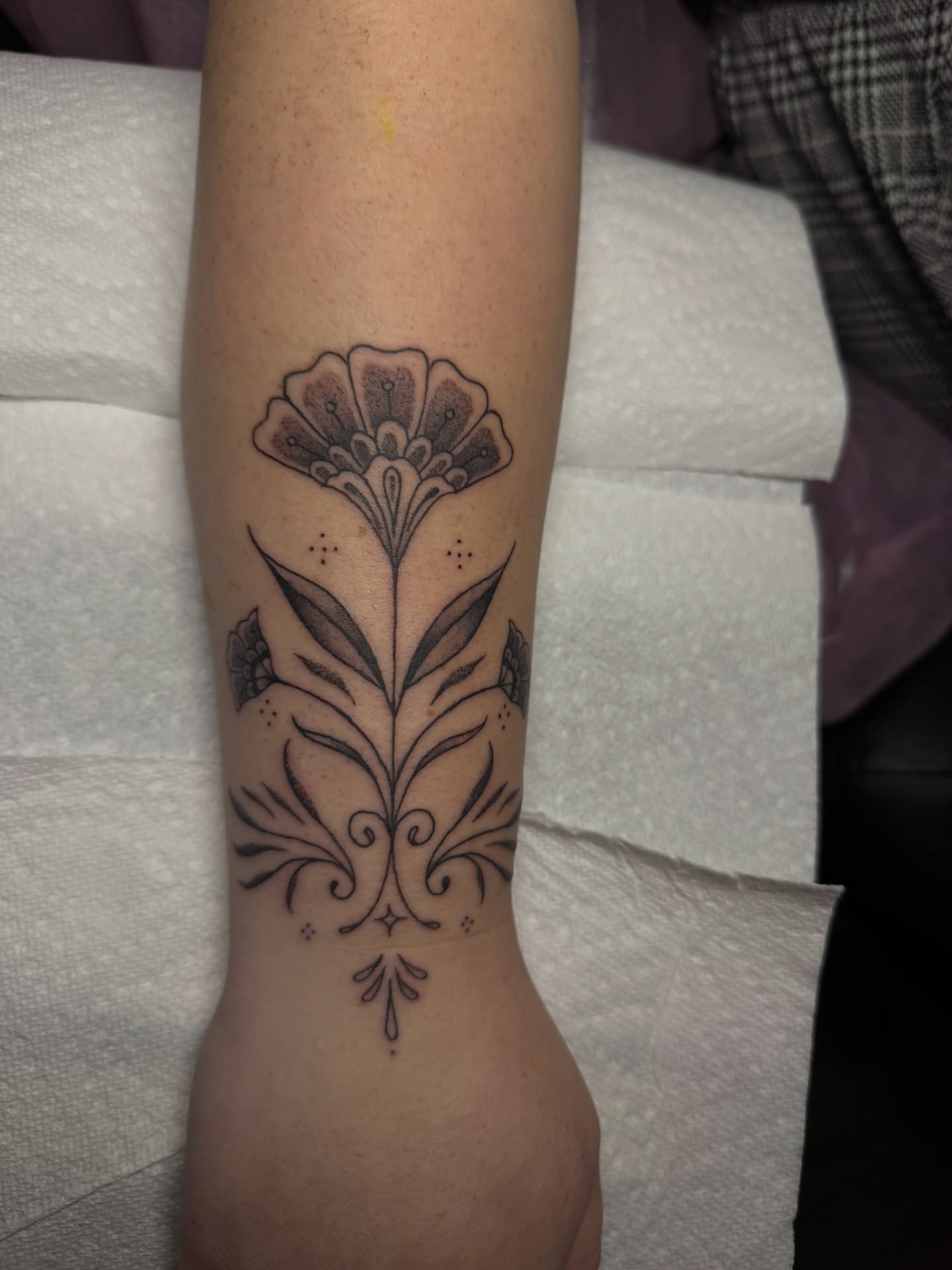Floral design black and grey tattoo on the forearm by Nathalie Briseno
