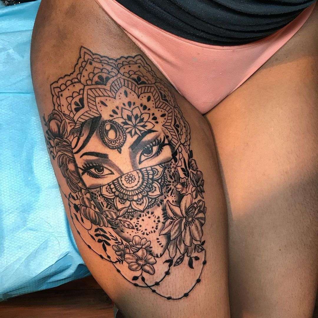 Woman with floral mask Chicano tattoo on the thigh by Emac, Baltimore, Maryland