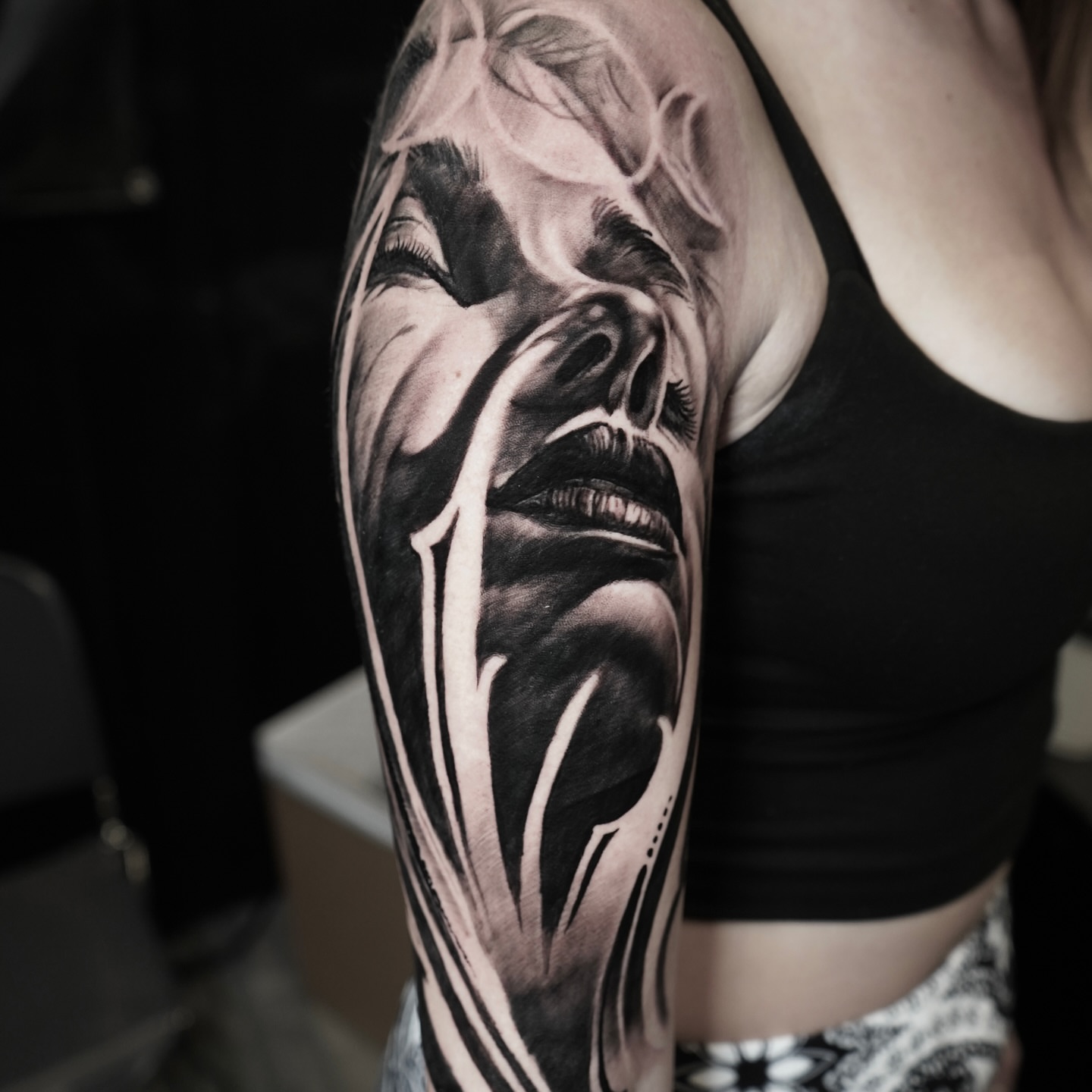 Woman's face realism tattoo on the upper arm by Darl Gnau