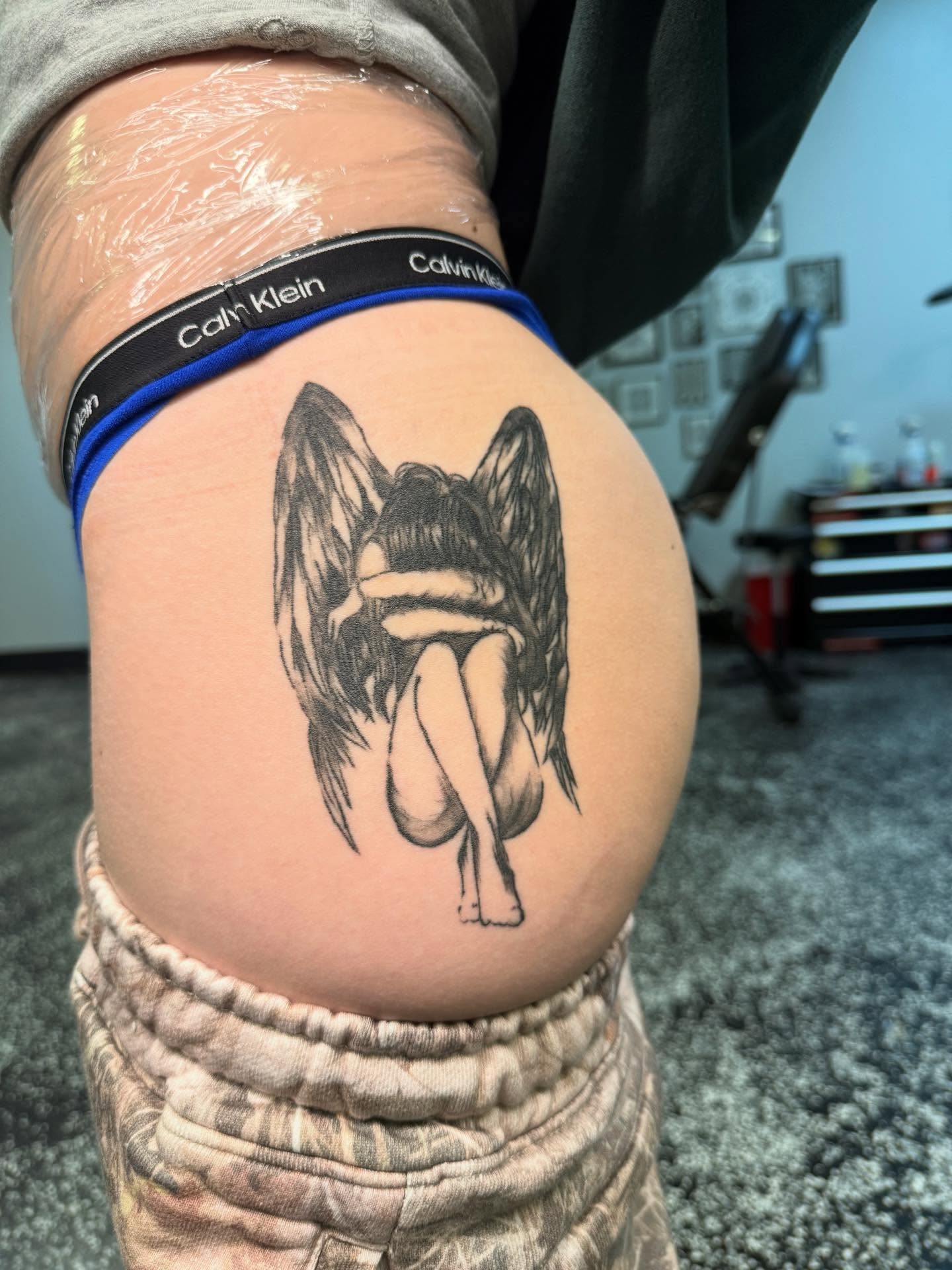 Angel black and grey tattoo on the thigh by Tattoos by Santos