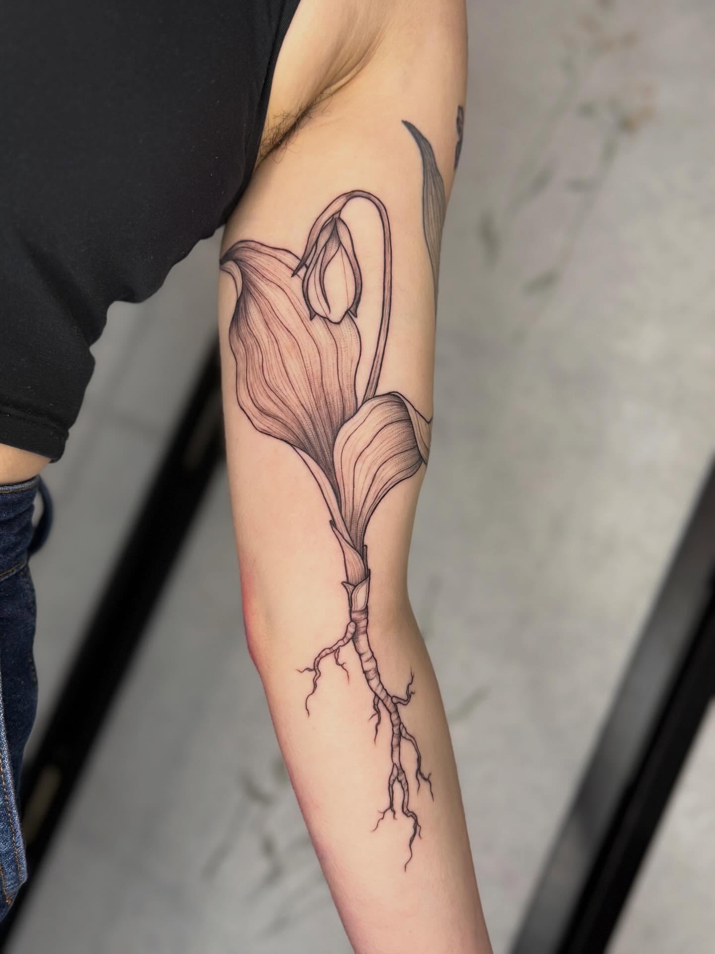 Calla lily black and grey tattoo on the forearm by Noelle Adrienne Tattoos