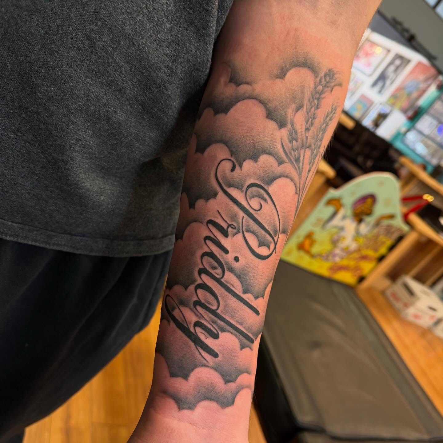 Wheat and clouds black and grey tattoo on the forearm by Madilynn Klassen