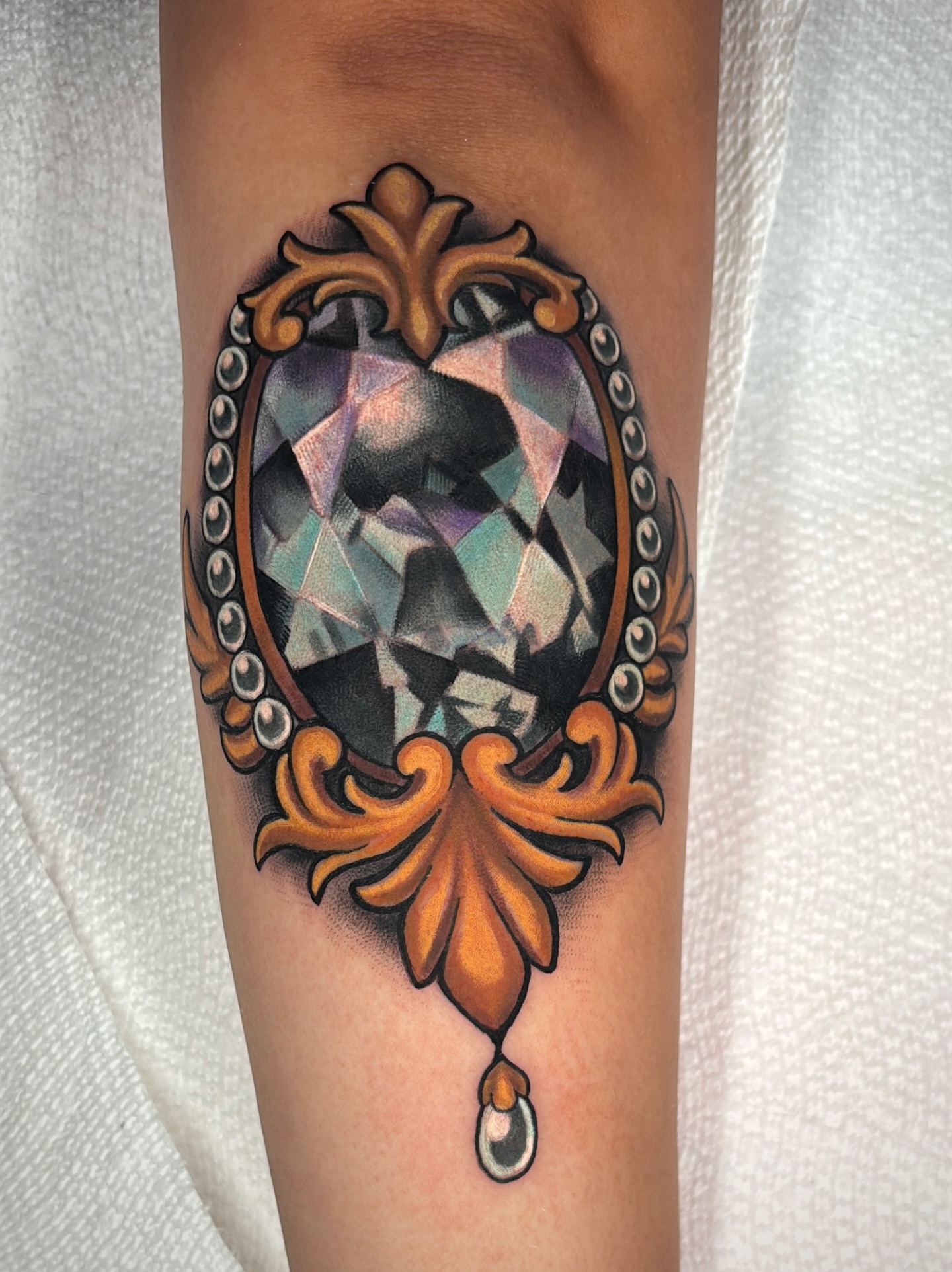 Gemstone realism tattoo on the forearm by Latesha Burnley