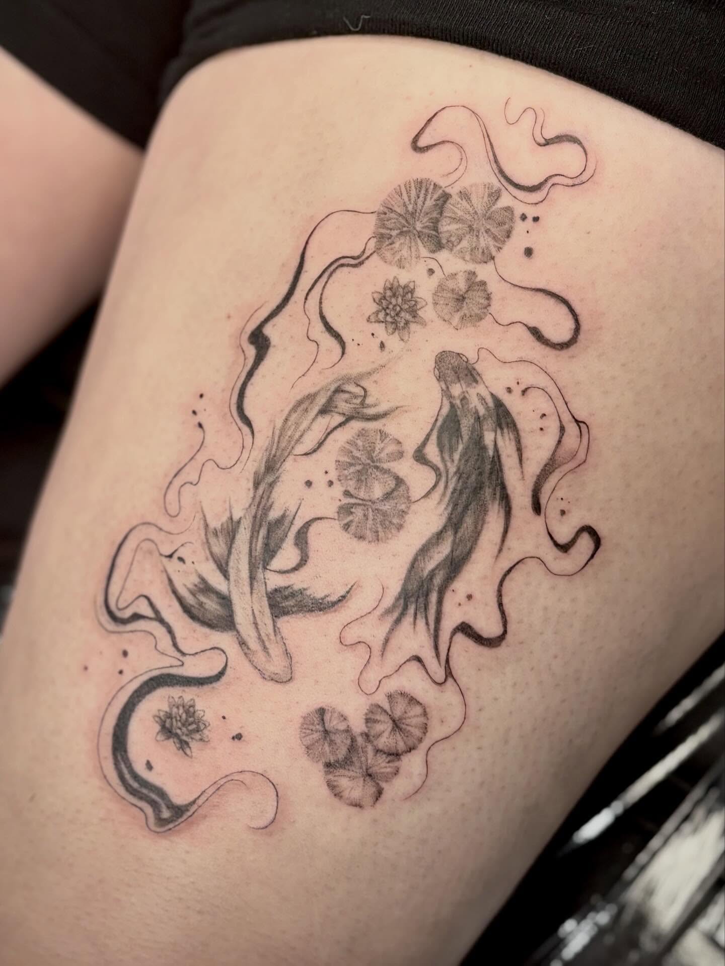 Fish and lily pads black and grey tattoo on the thigh by Jazzlyn Hous