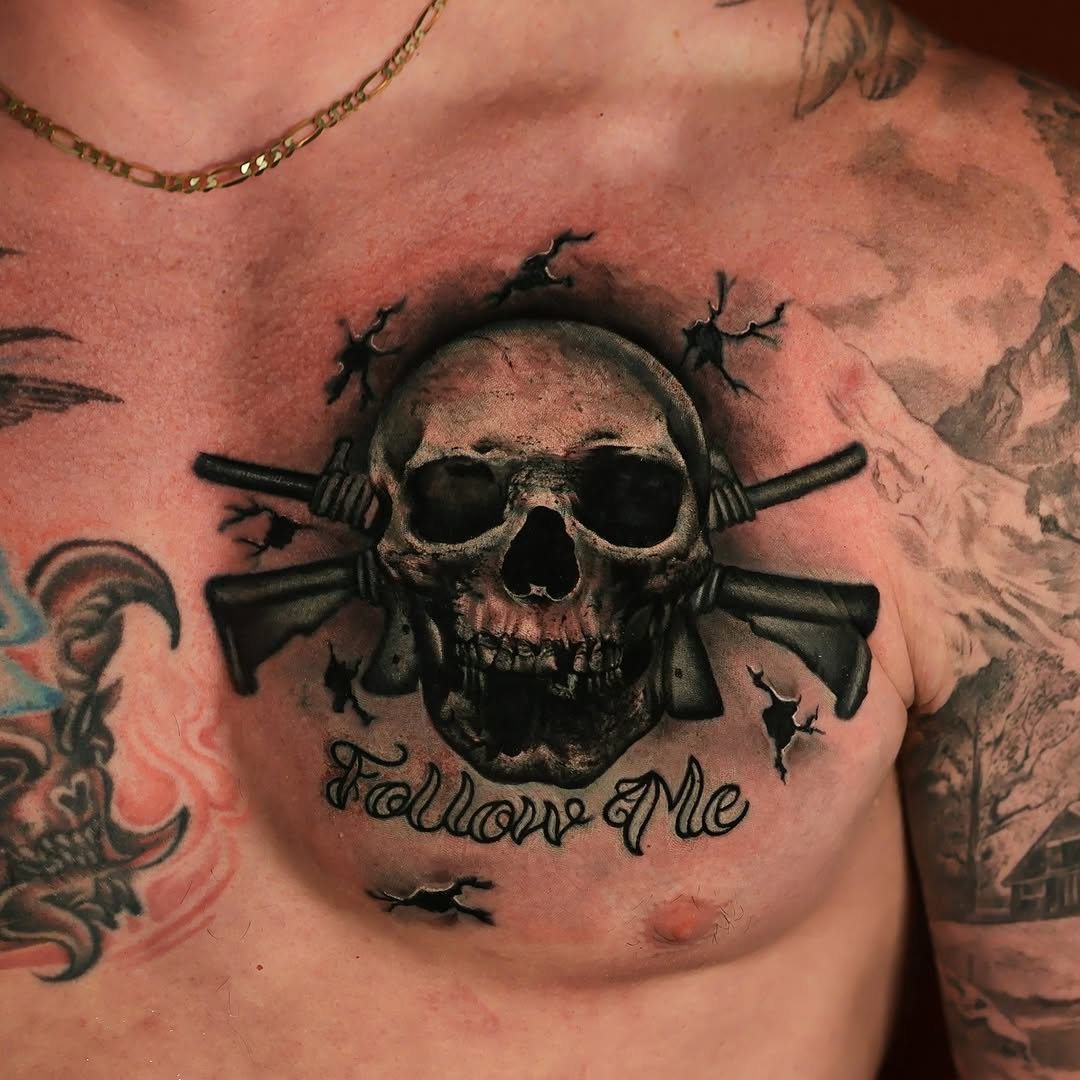 Skull with crossed rifles and lettering realism tattoo on the chest by Felipe Andrade