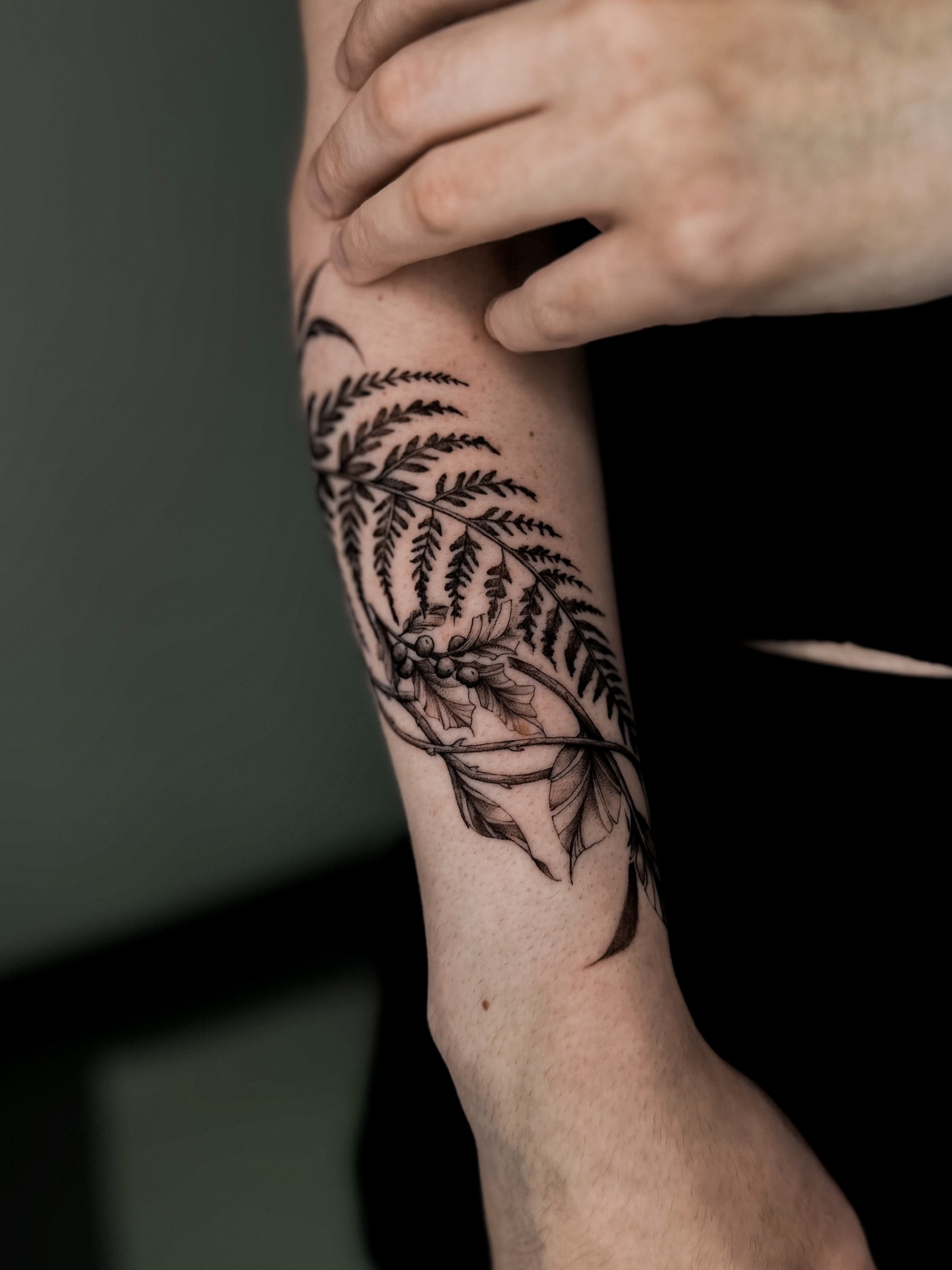 Fern black and grey tattoo on the forearm by Lauren