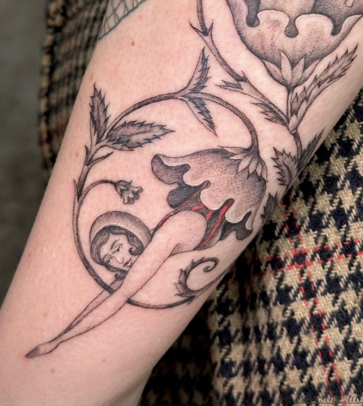 Nude woman with floral elements realism tattoo on the forearm by Carmen Figueroa, New York, New York