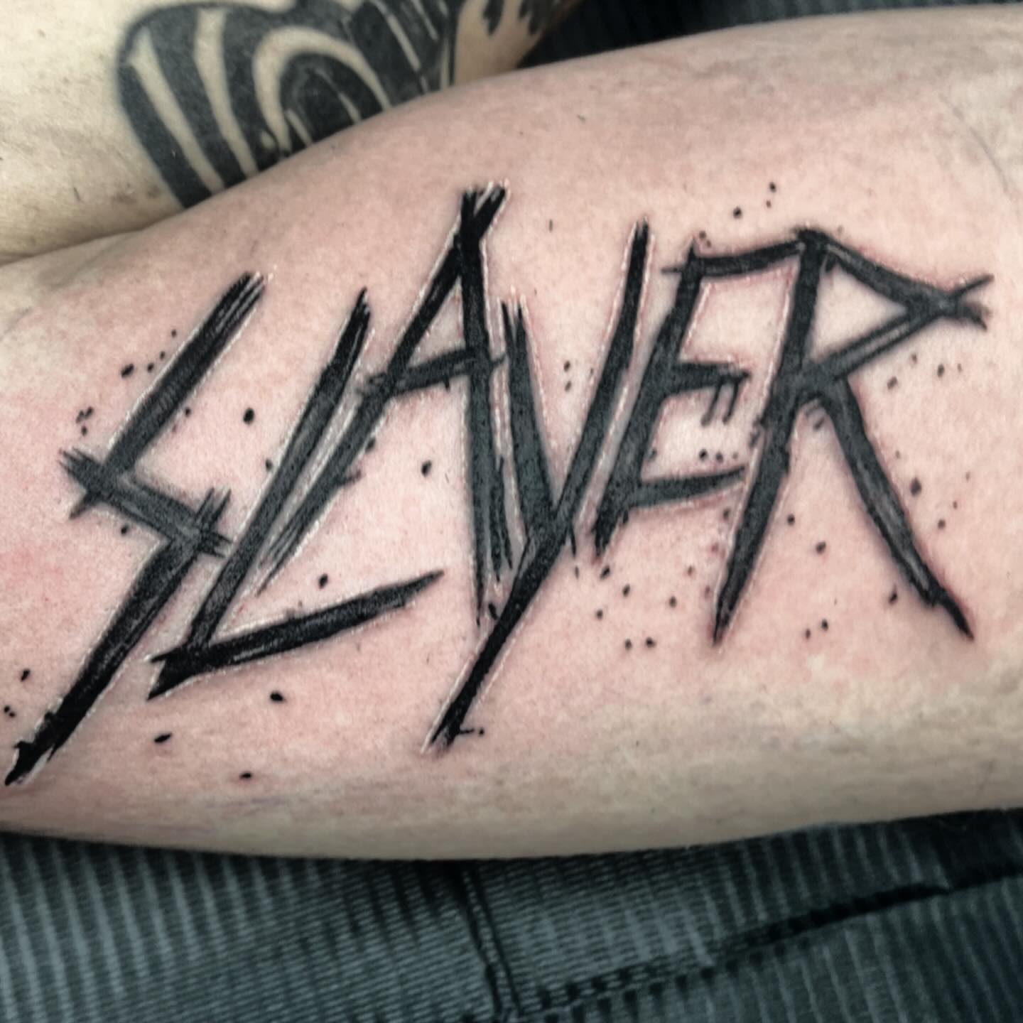Slayer black and grey tattoo on the forearm by Bobby Glennon