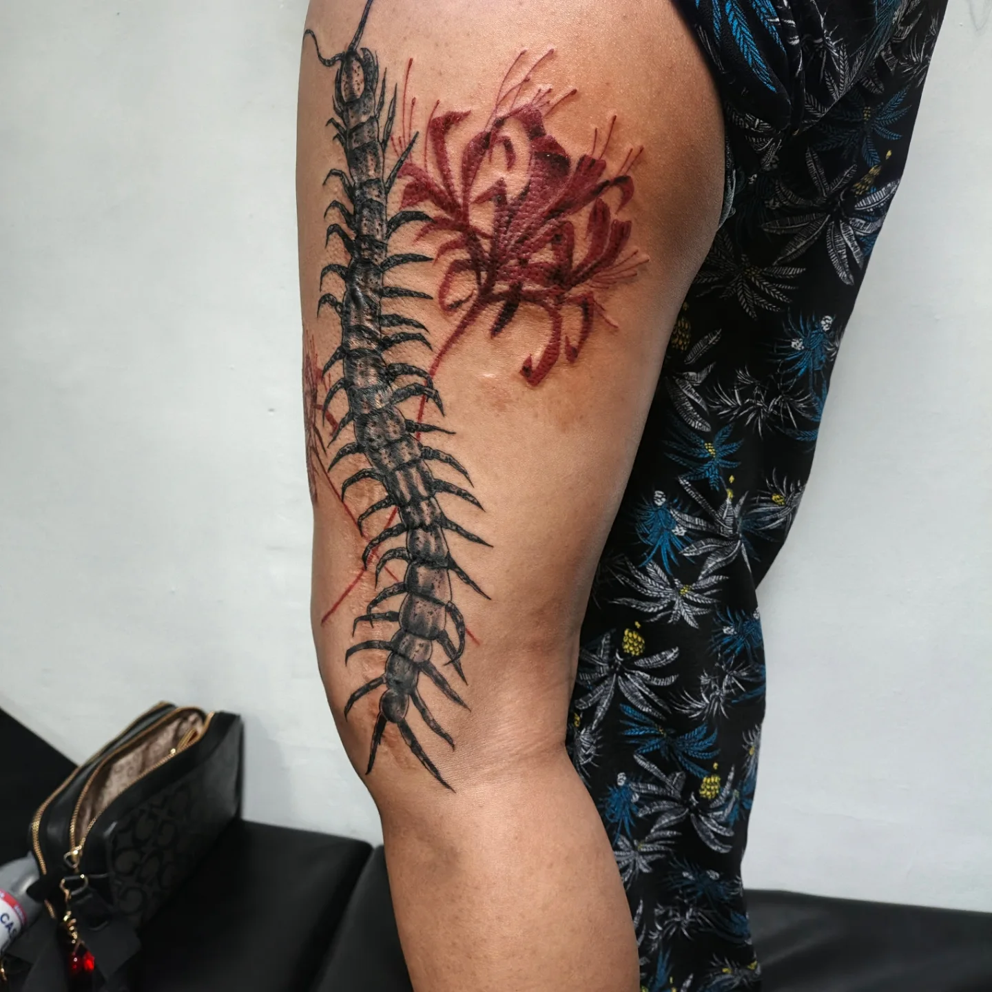 Centipede and flower realism tattoo on the forearm by Alexander Tattooink