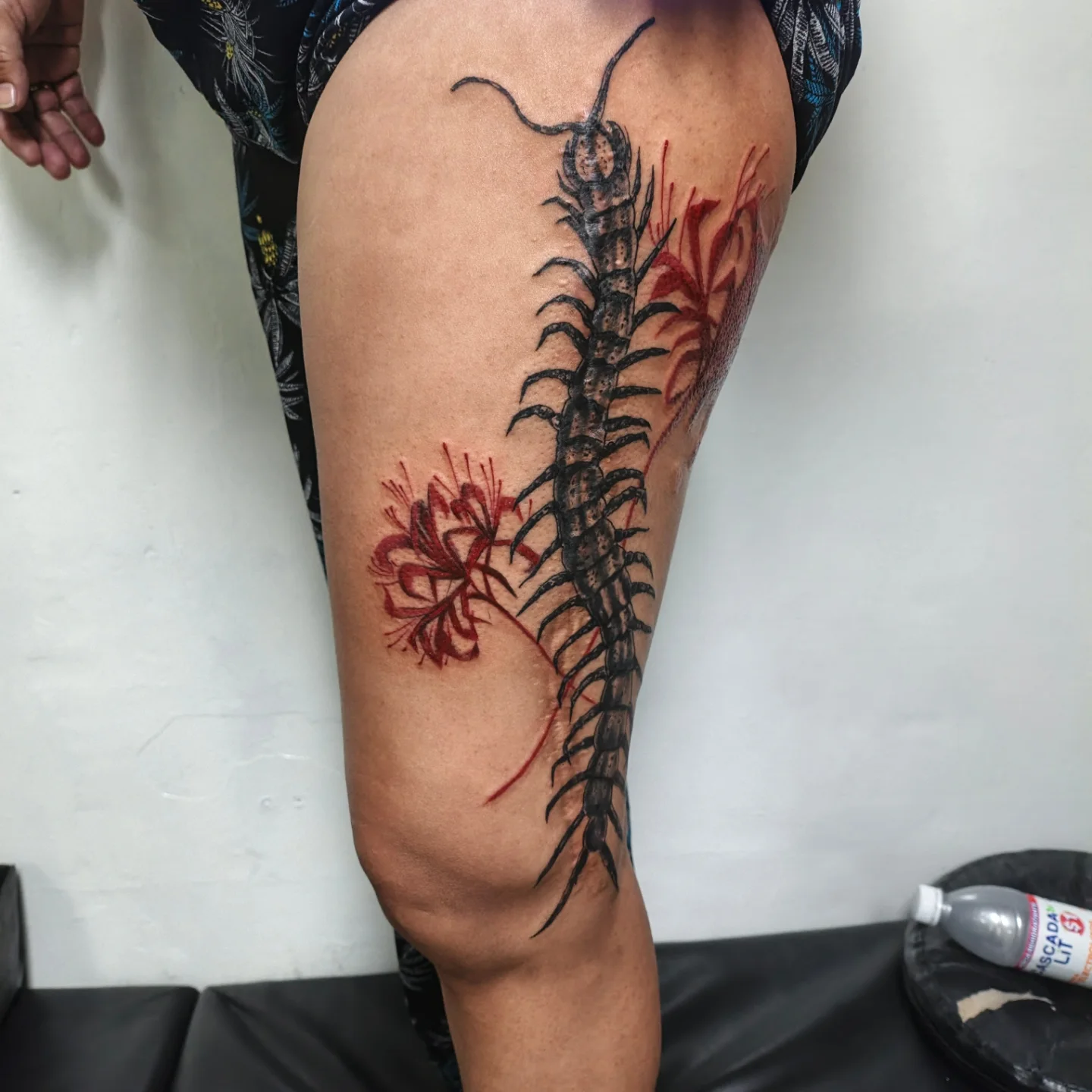 Centipede and flowers realism tattoo on the thigh by Alexander Tattooink