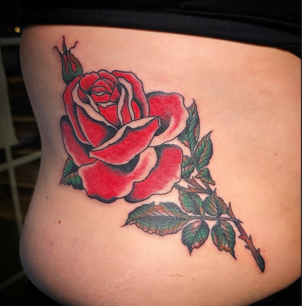 Red rose American traditional tattoo on the ribs by Columbus tattoo artist