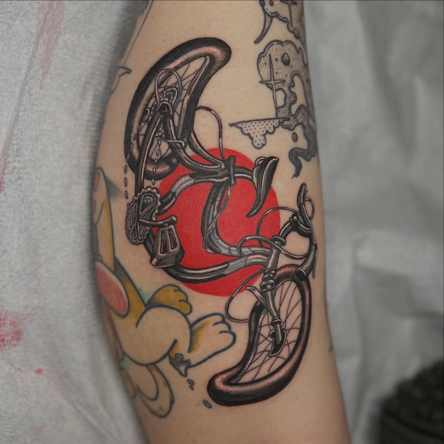 Bicycle and sun American traditional tattoo on the forearm by Alex Santaloci