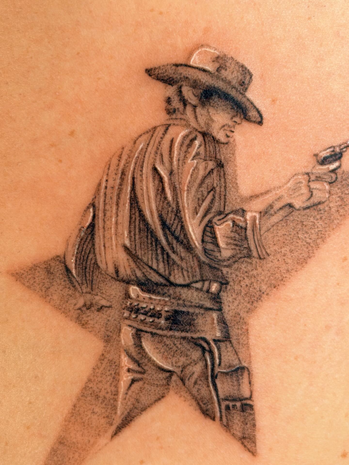 Cowboy with gun black and grey tattoo on the shoulder by Nate Weaver