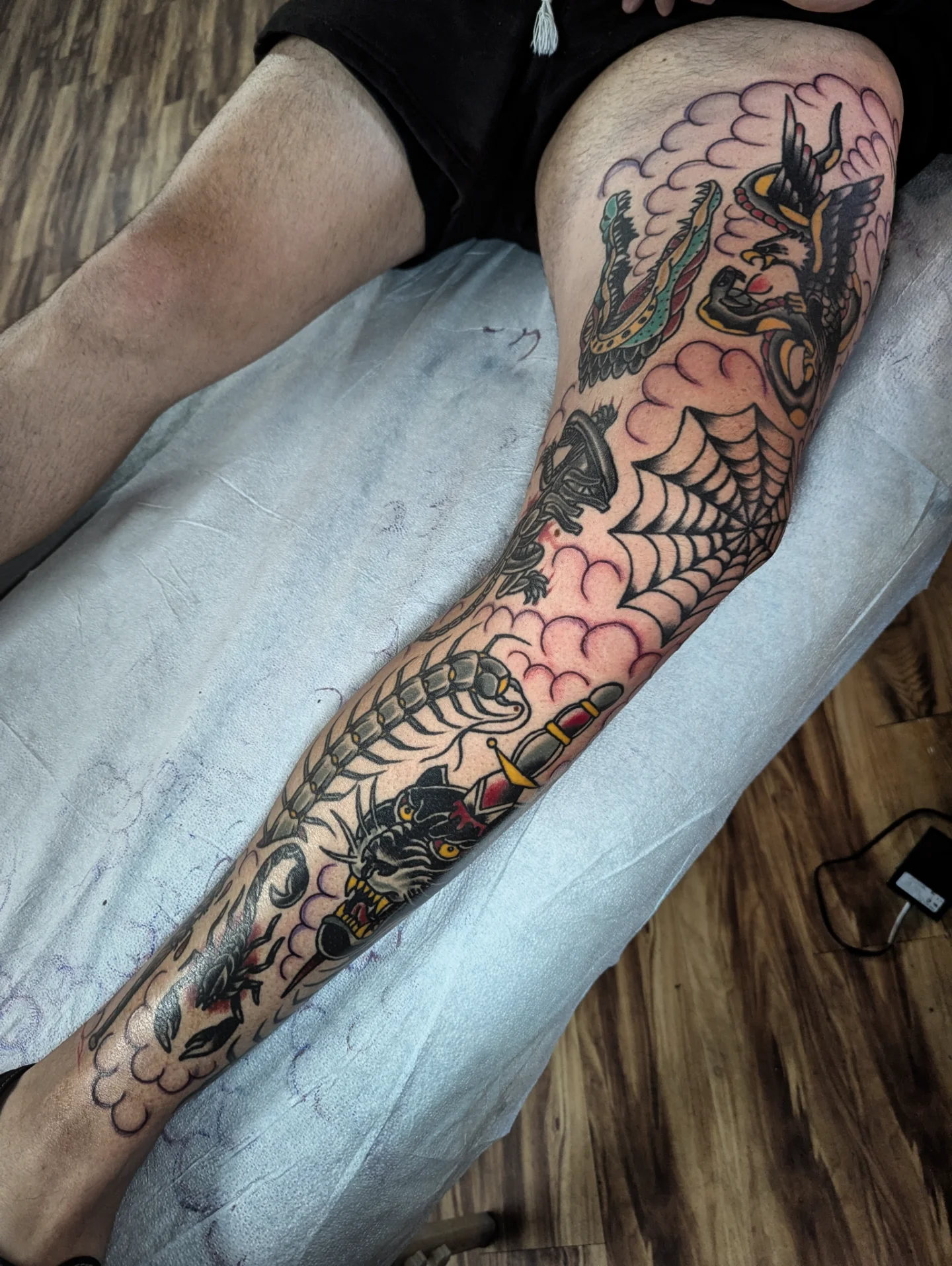 Serpent and dragon American traditional tattoo on the leg by Eric Ward