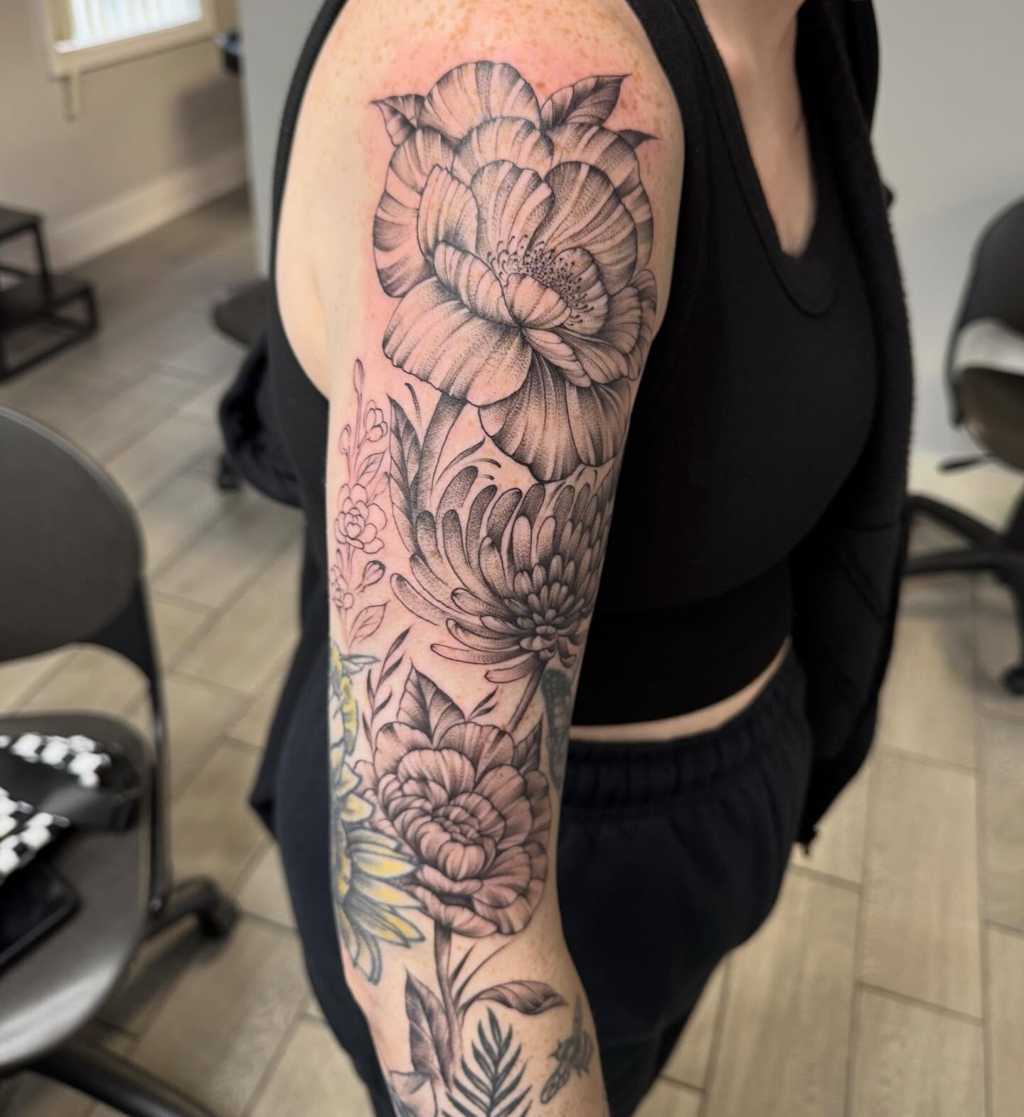 Floral bouquet realism tattoo on the upper arm by Joey Flaherty