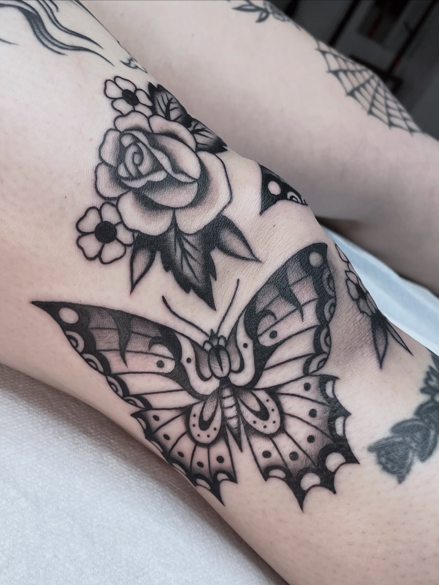 Butterfly and rose American traditional tattoo on the forearm by Dakota Jenner