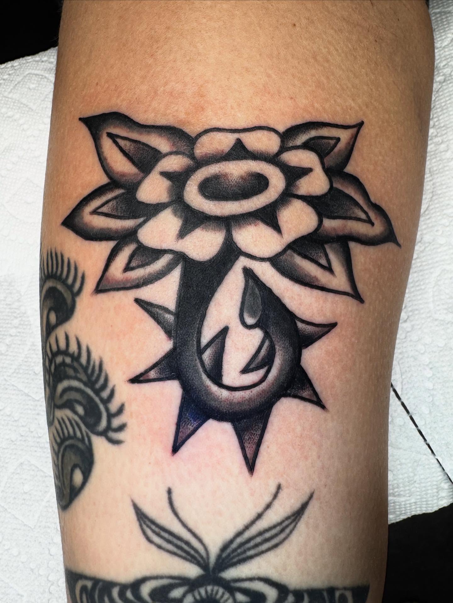 Flower and anchor black and grey tattoo on the forearm by JoJo Benton