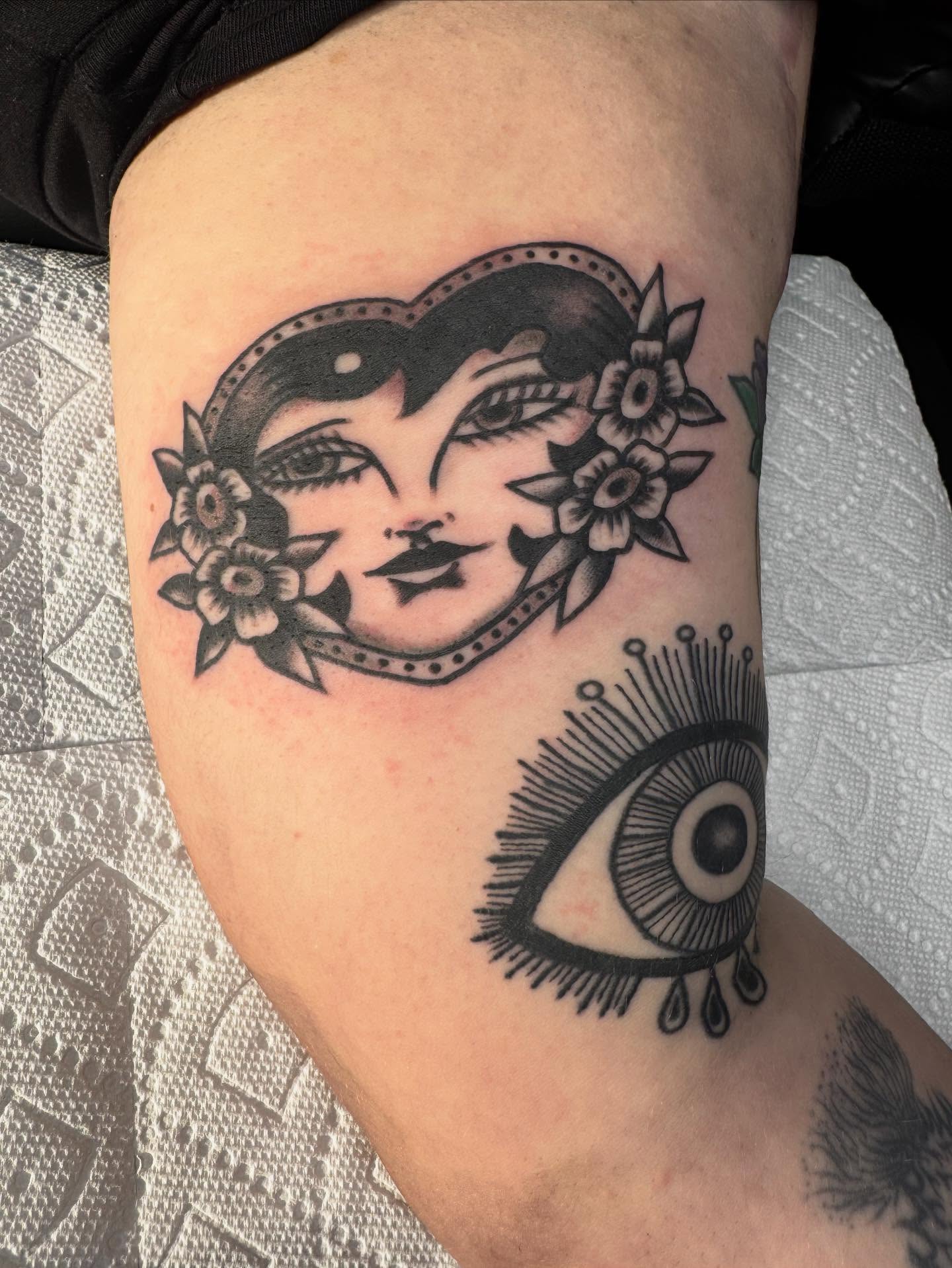 Female face with flowers American traditional tattoo on the forearm by JoJo Benton