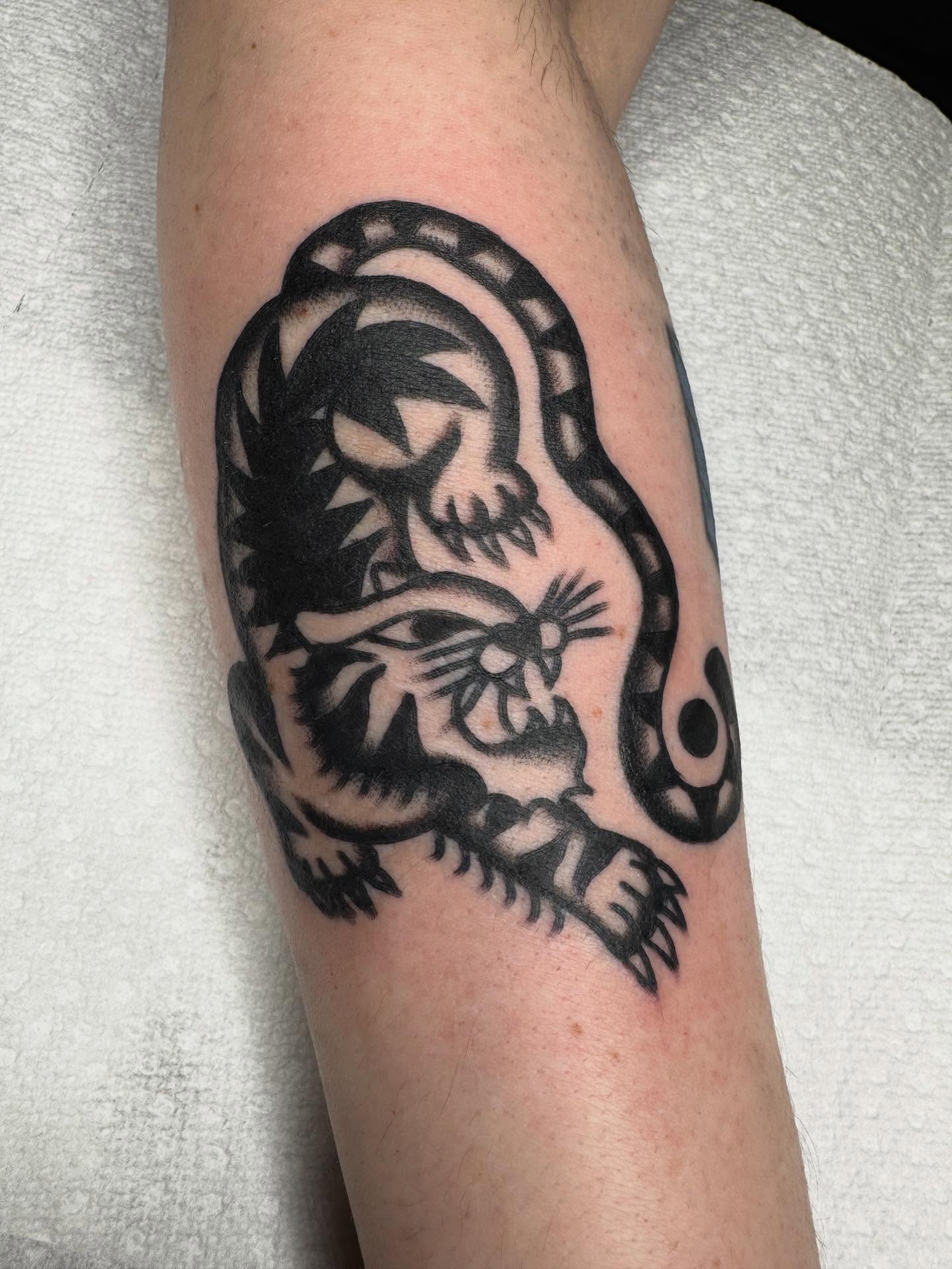 Skull and snake American traditional tattoo on the forearm by JoJo Benton