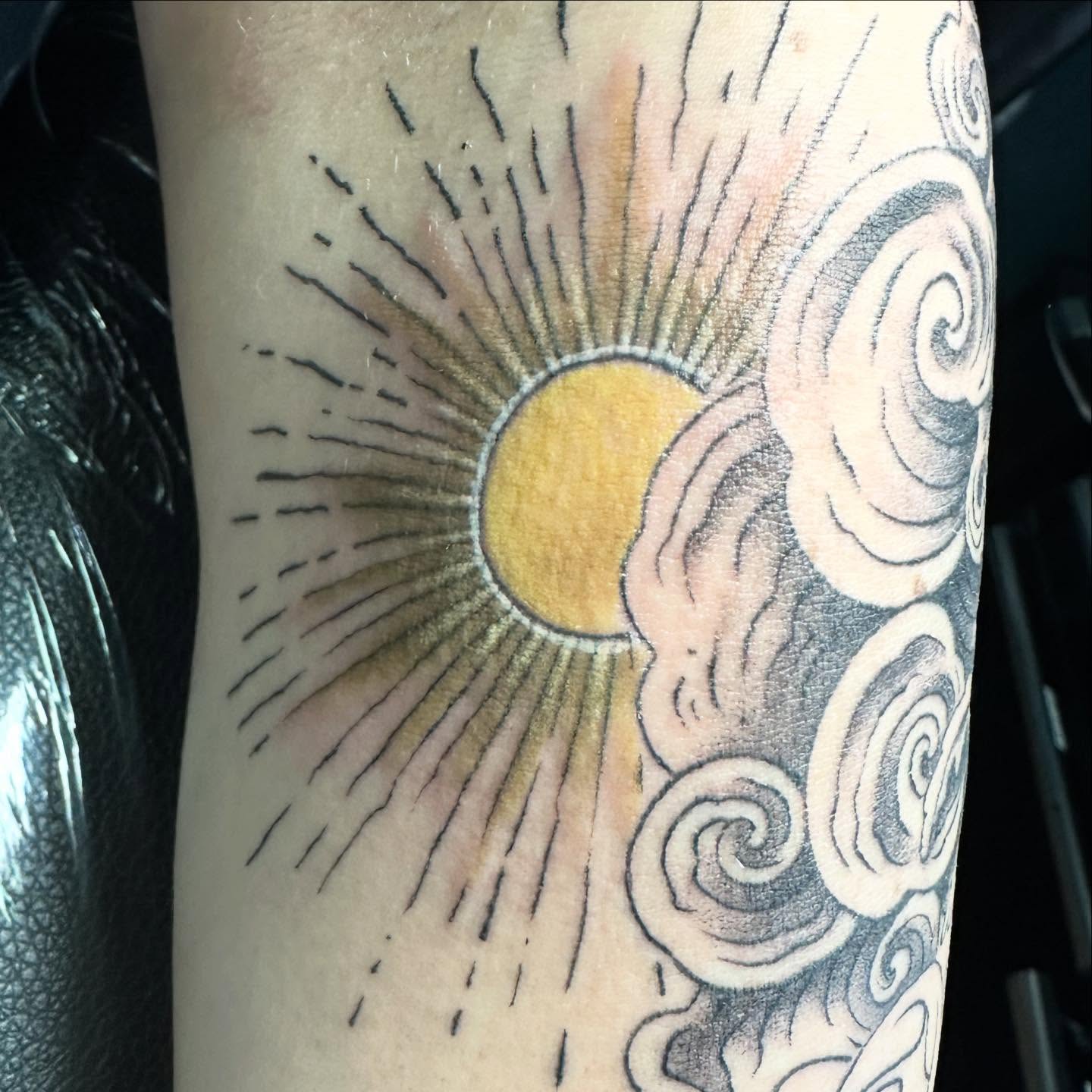Sun and clouds dotwork tattoo on the forearm by Sarah Nash